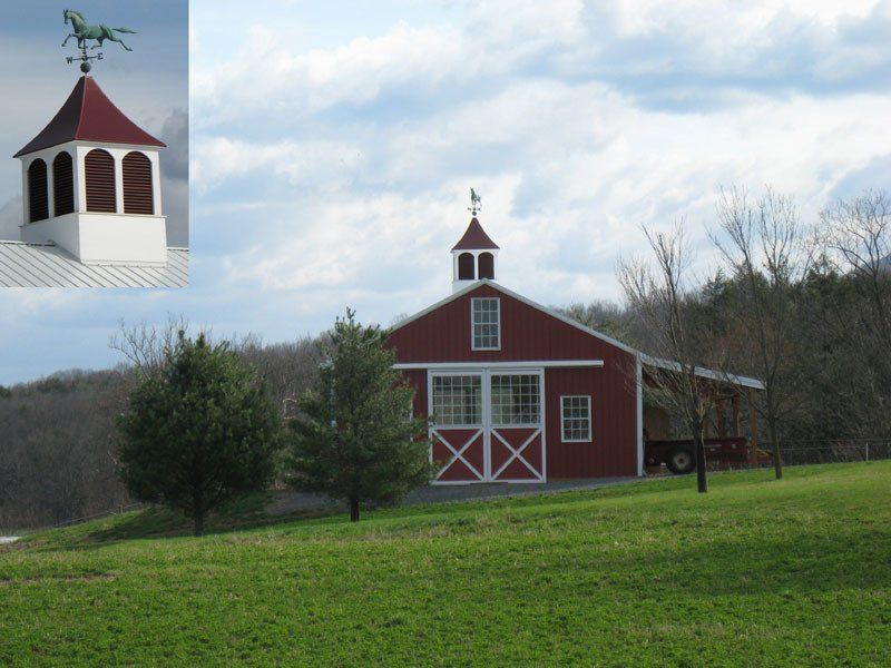 A red barn with a weather vane on top of it