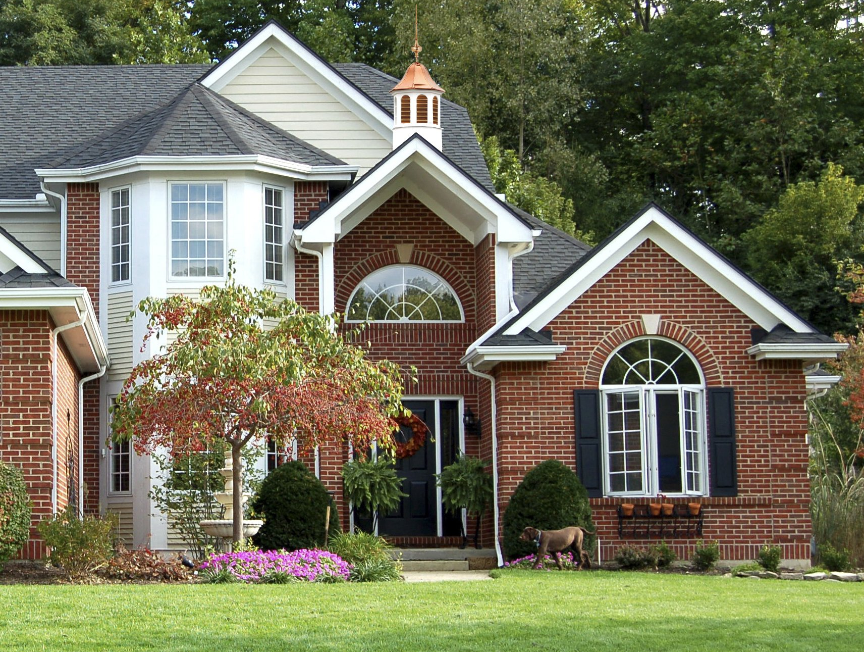 a large brick house with white trim and black shutters