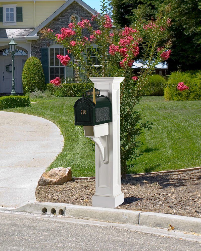A mailbox on a white post in front of a house