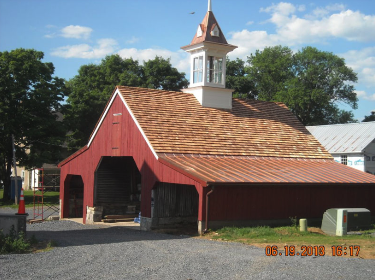 A red barn with a clock tower on top of it