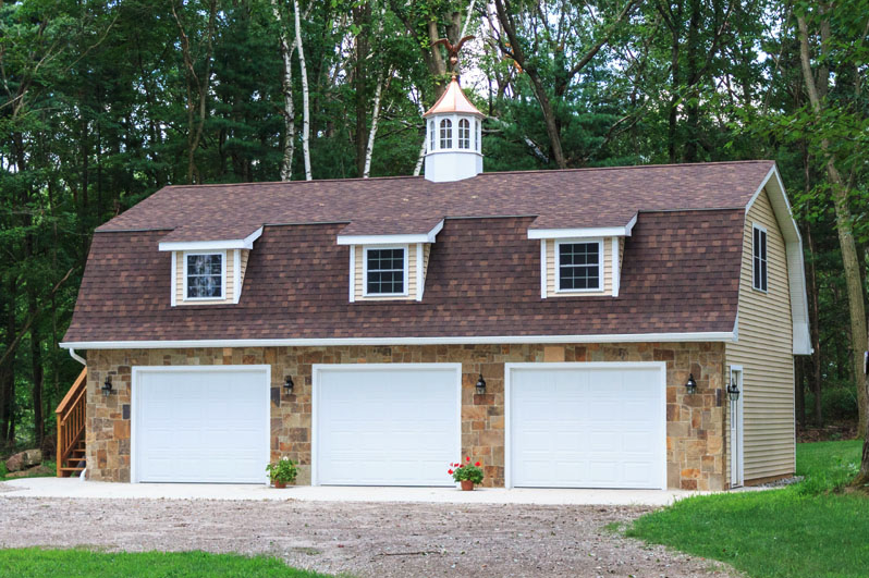 A large garage with a brown roof and white doors