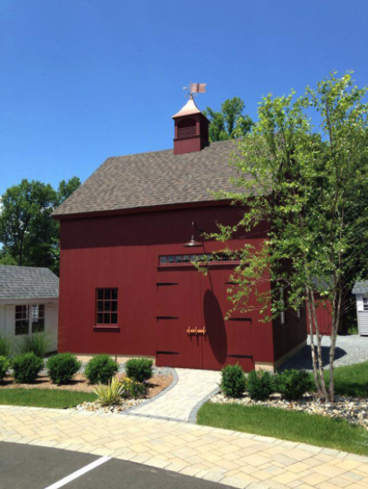 A red barn with a flag on top of it