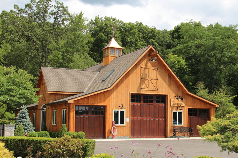 A large wooden barn with a cupola on top of it