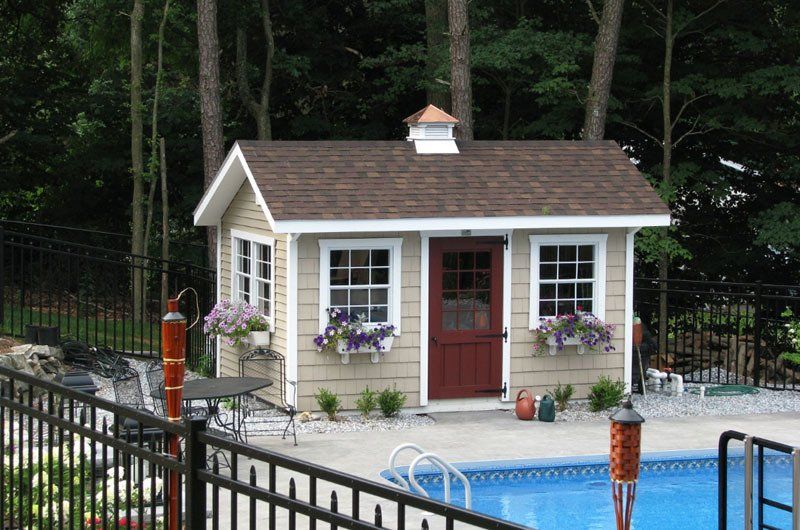 A small house sits next to a swimming pool