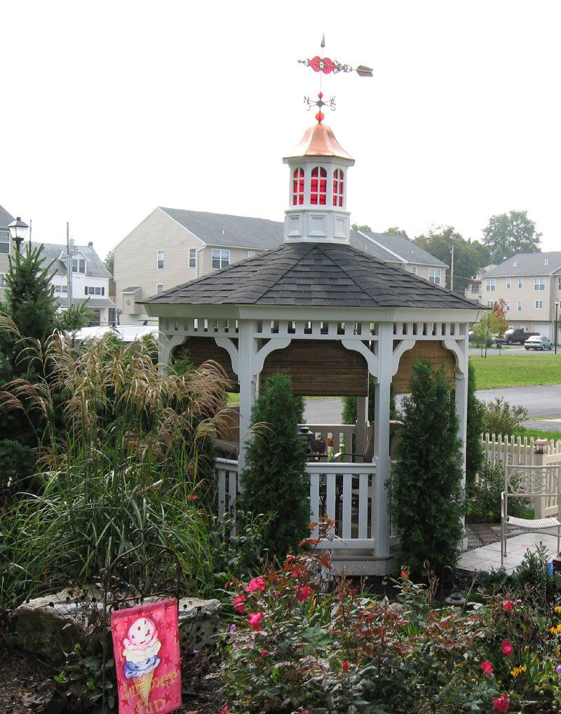 A gazebo with a weather vane on top of it