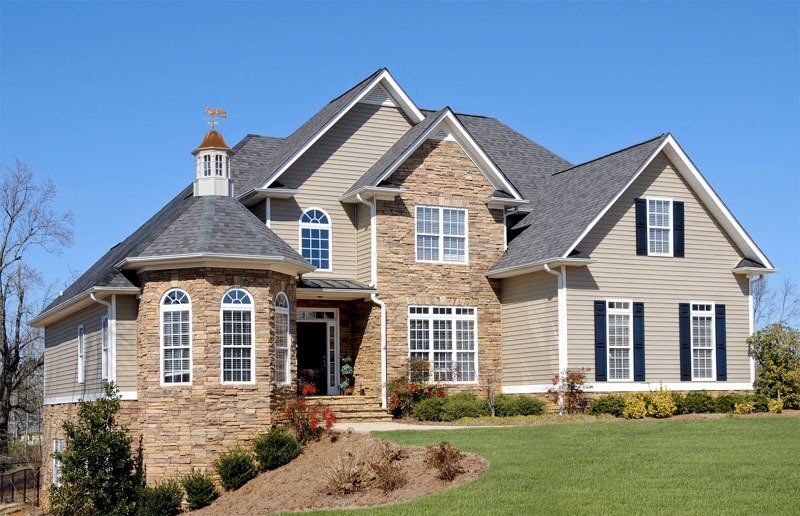 A large house with a blue sky in the background
