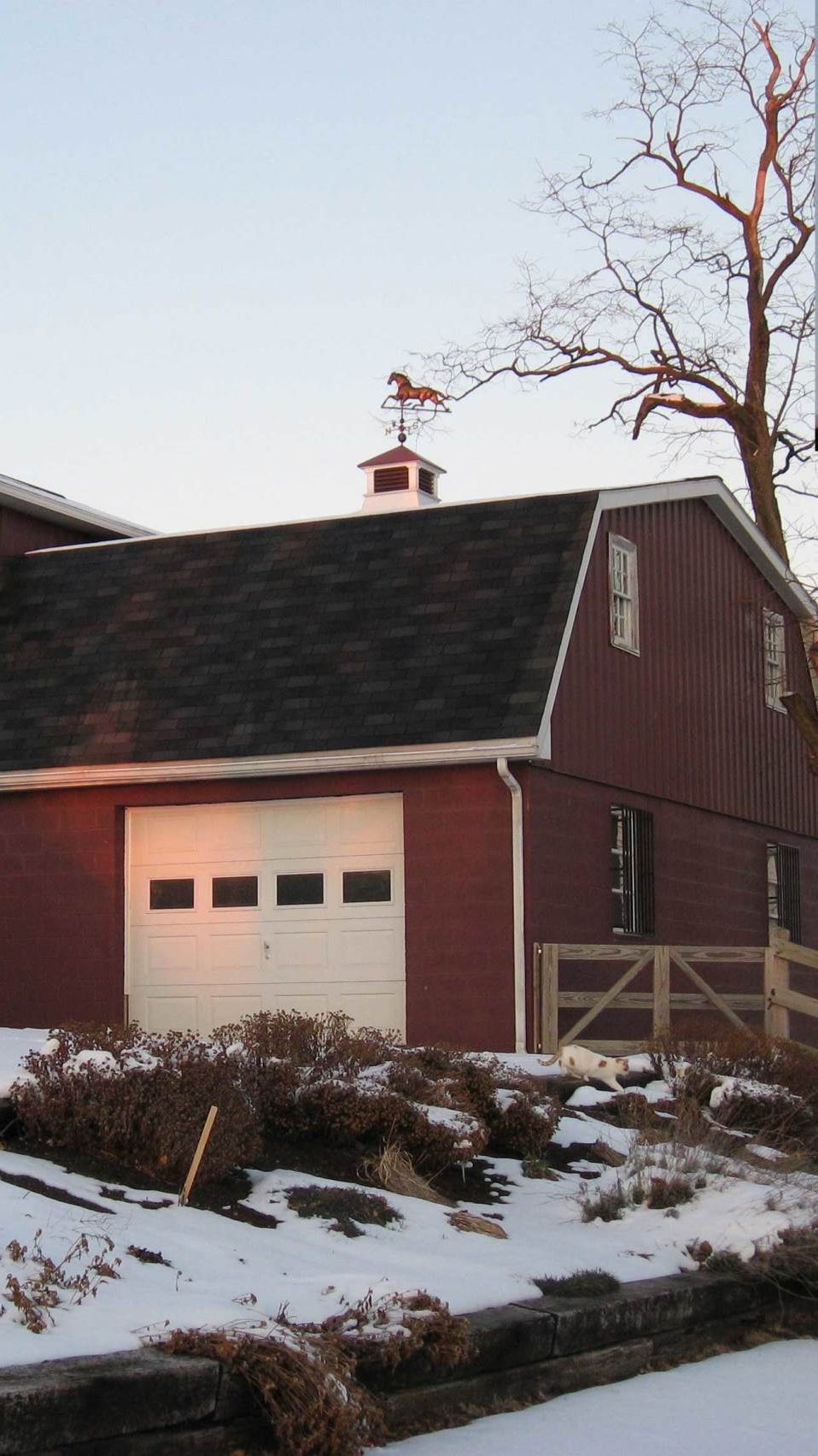 a red barn with a weather vane on top of it
