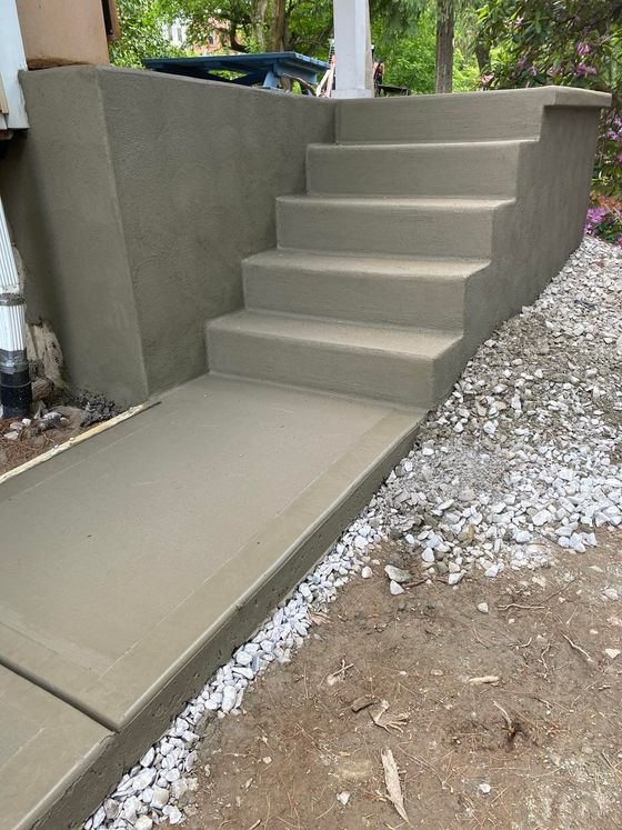 A set of concrete stairs leading up to a house.