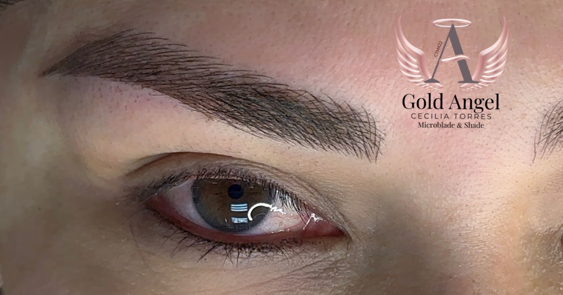 Un primer plano del ojo de una mujer con un tatuaje en las cejas.