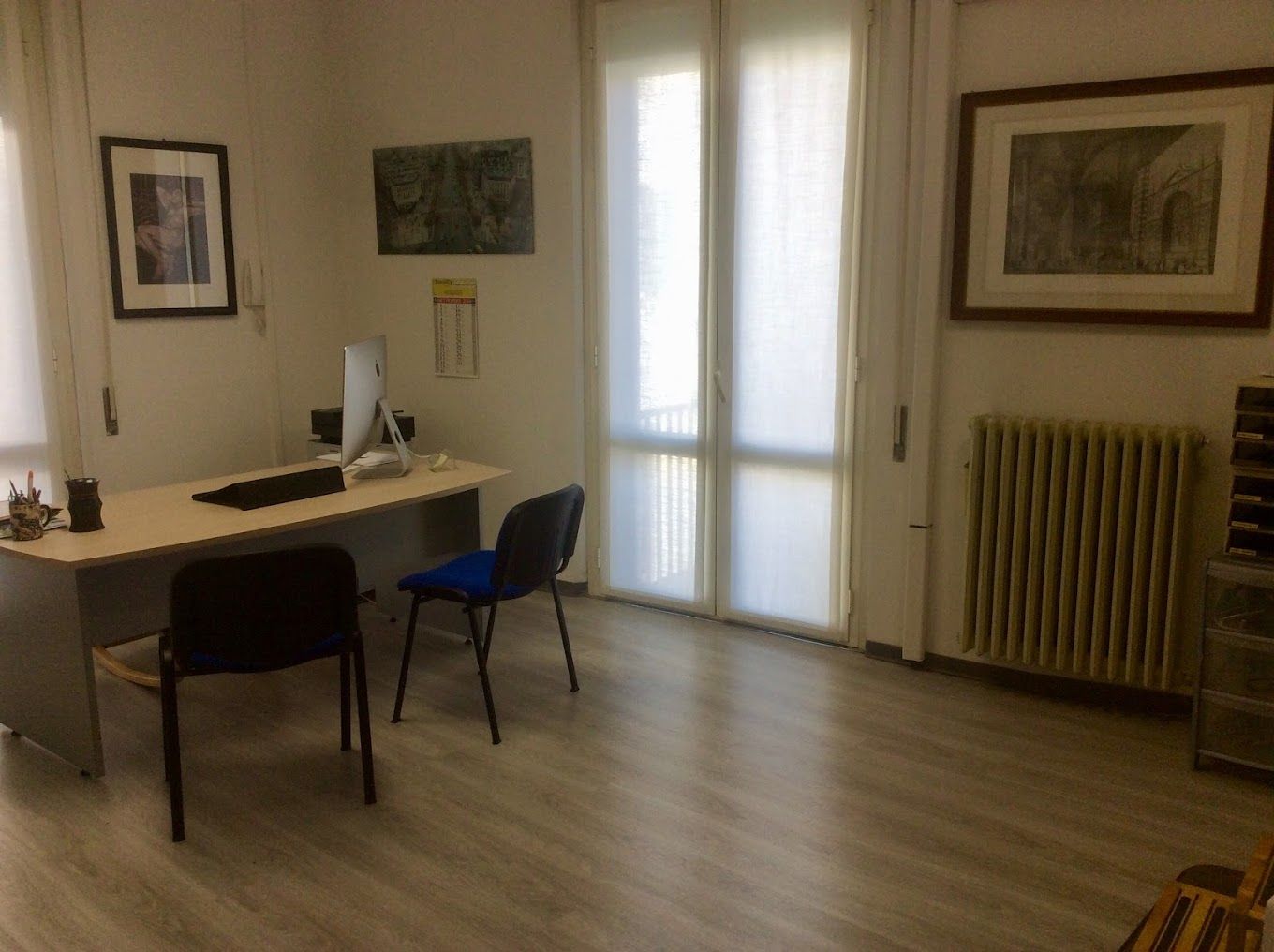 una stanza con un tavolo e due sedie e un computer .