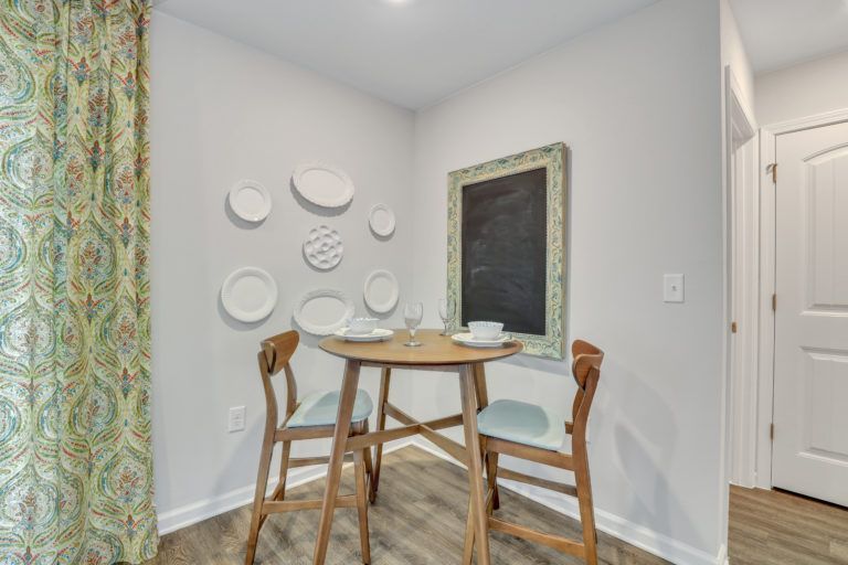 There is a table and chairs in the corner of the room.