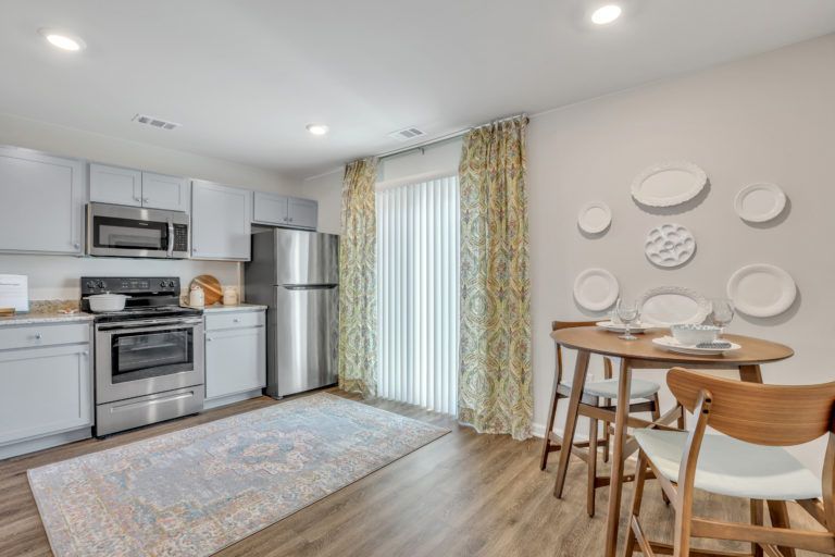 A kitchen with a table and chairs and a refrigerator.