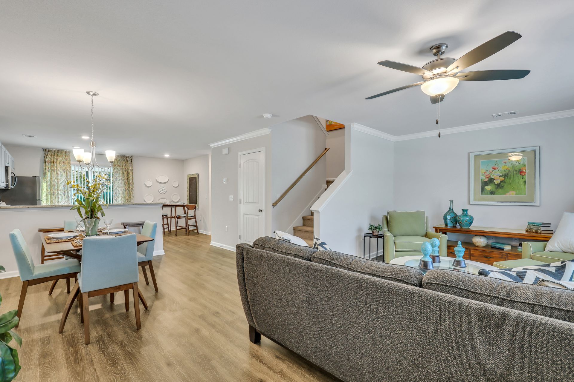 A living room with a couch , chairs , and a ceiling fan.