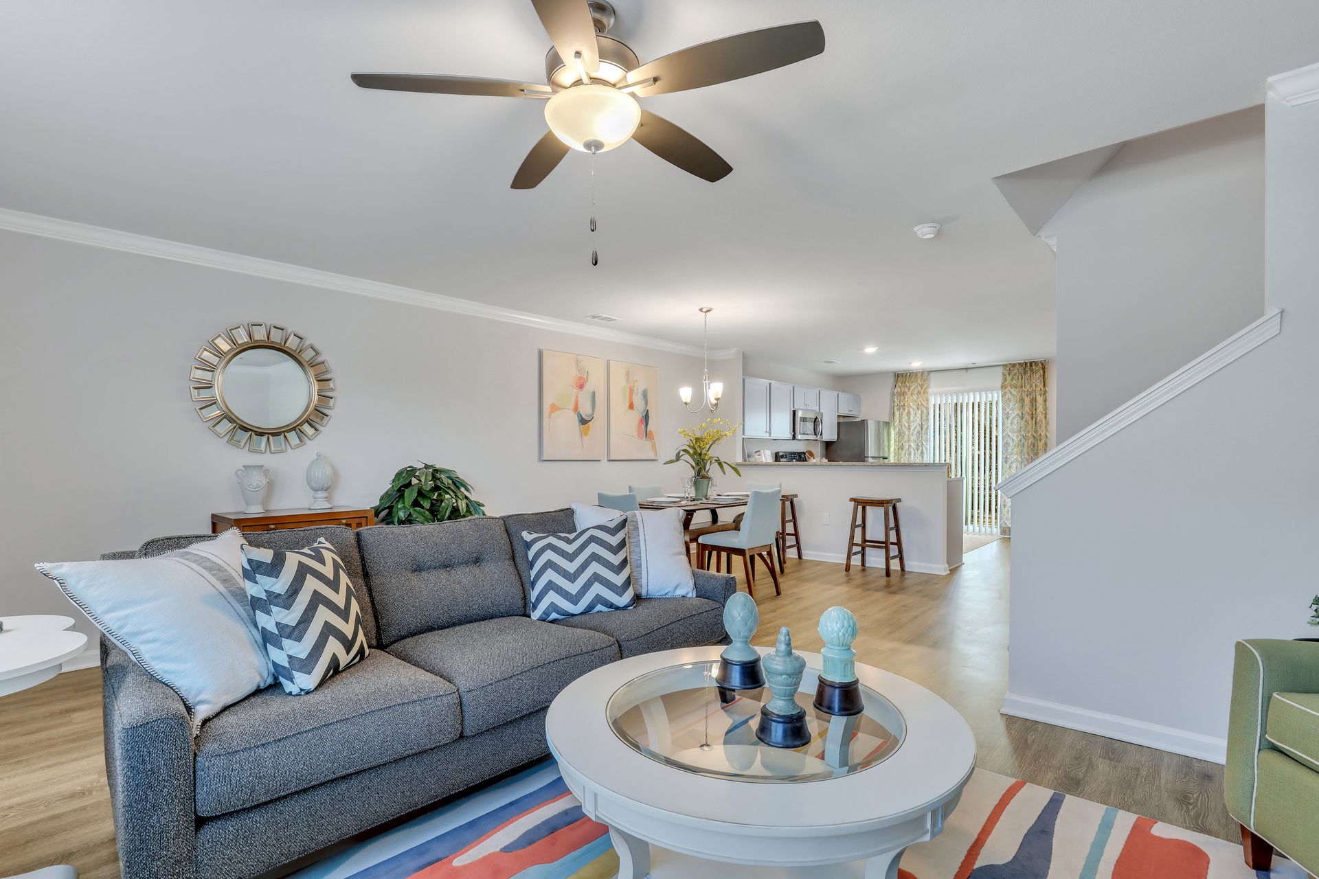 A living room with a couch , coffee table , and ceiling fan.