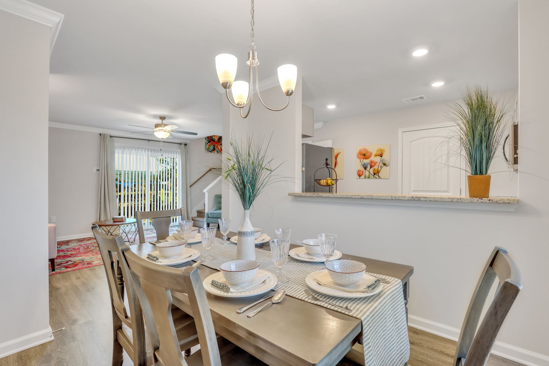 A dining room table and chairs in a house with plates and silverware on it.