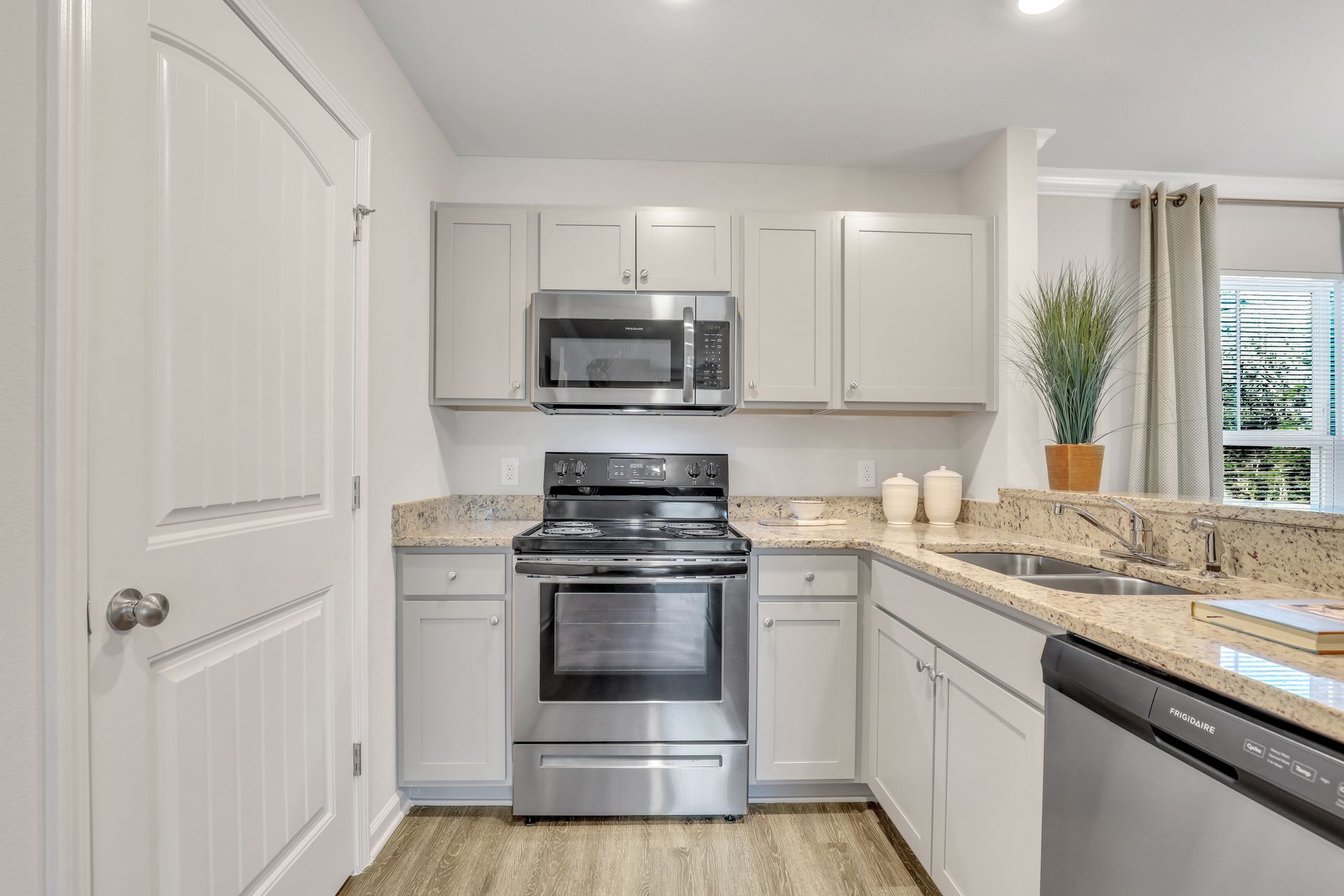 A kitchen with stainless steel appliances and white cabinets.