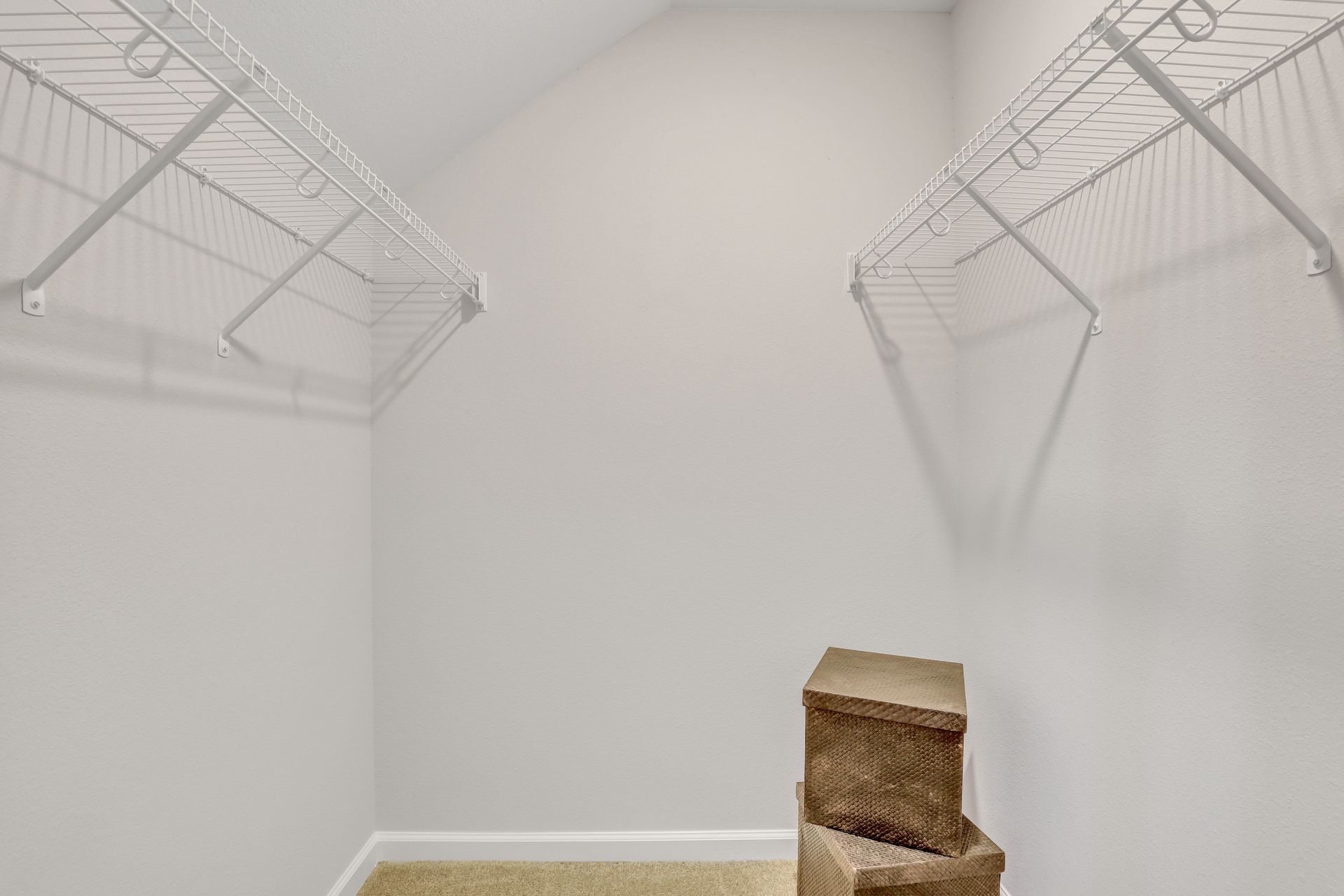 A walk in closet with a stack of boxes on the floor.