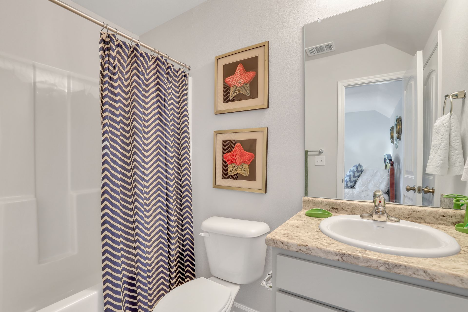 A bathroom with a toilet , sink , and shower curtain.