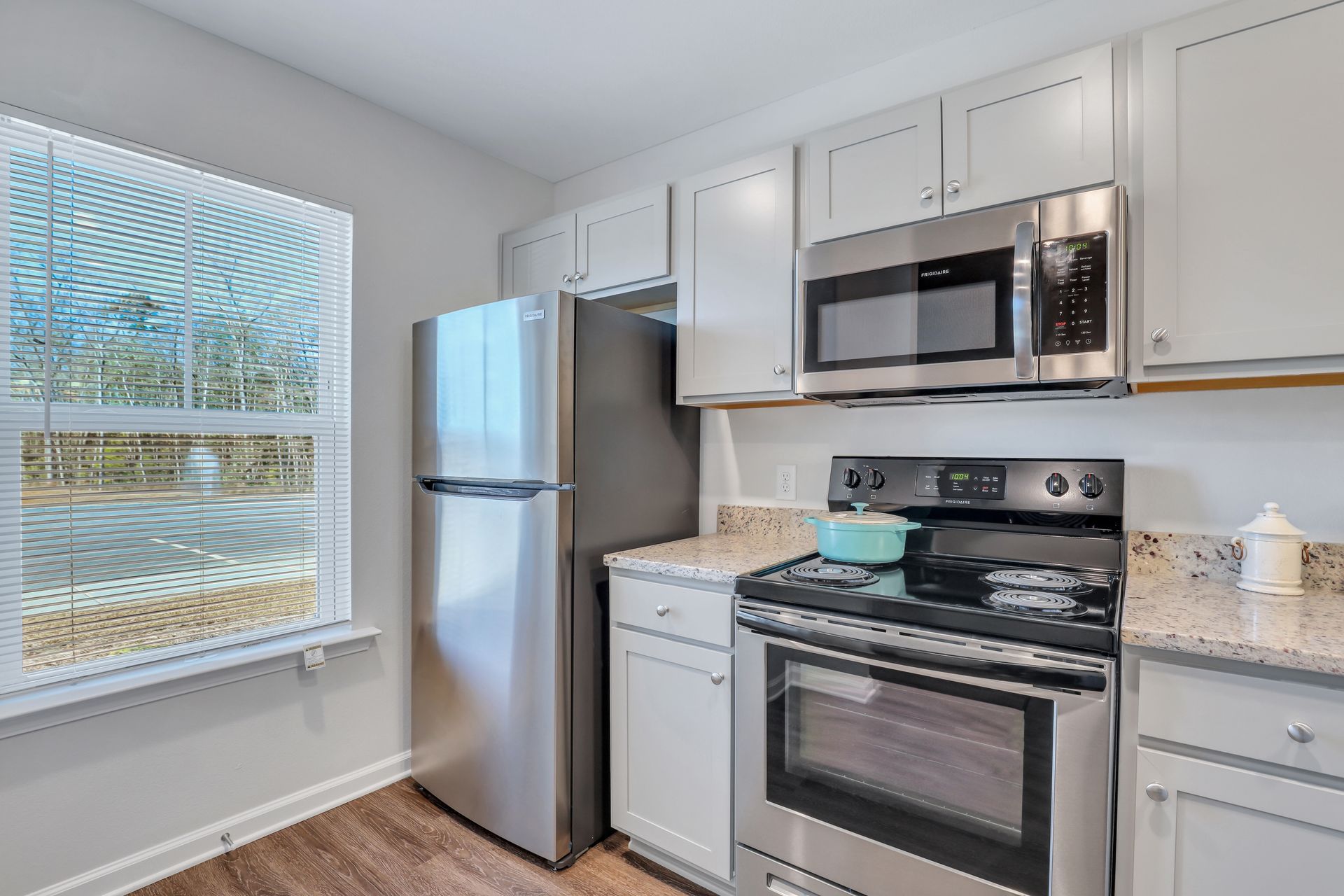 A kitchen with stainless steel appliances and white cabinets.