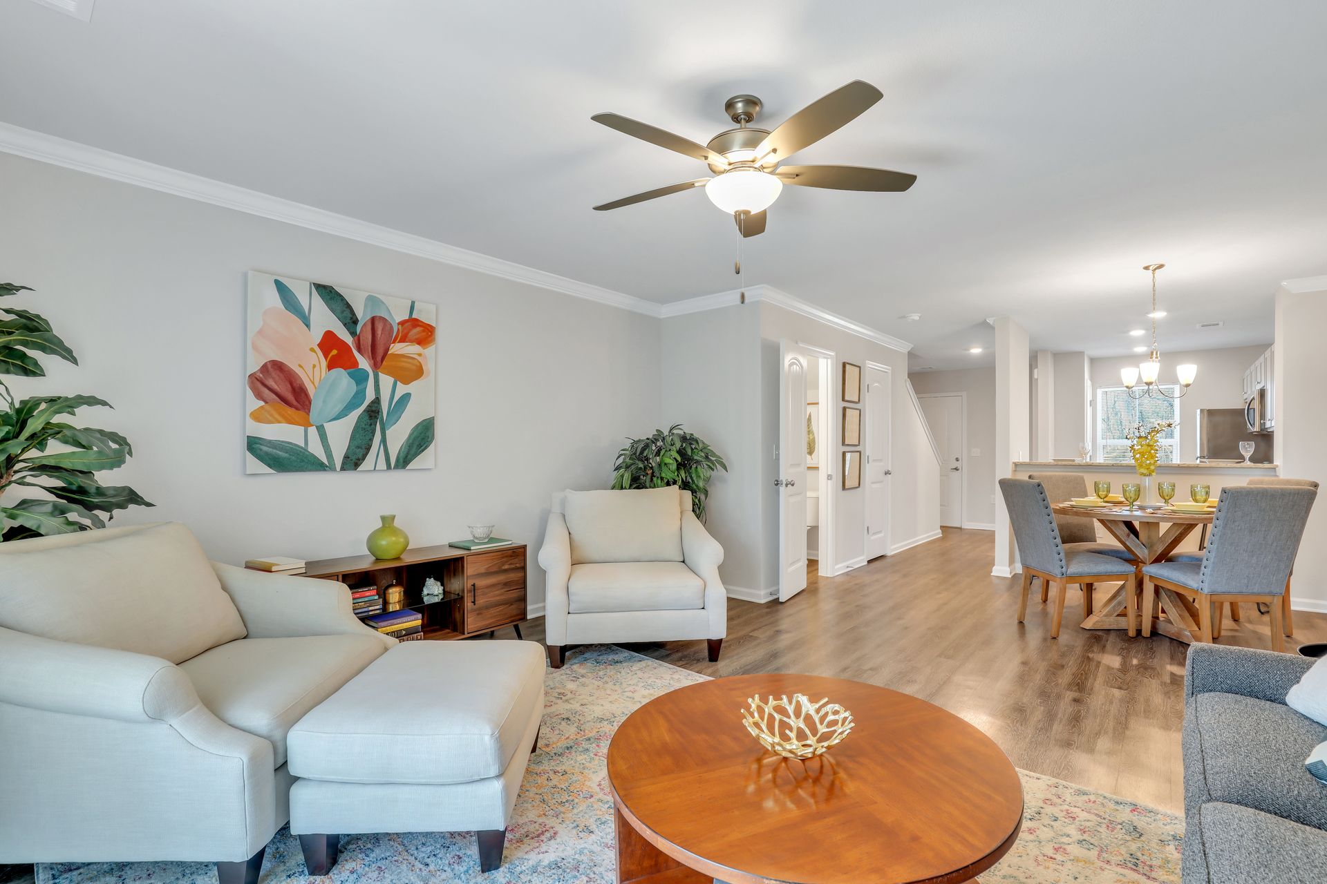 A living room filled with furniture and a ceiling fan.