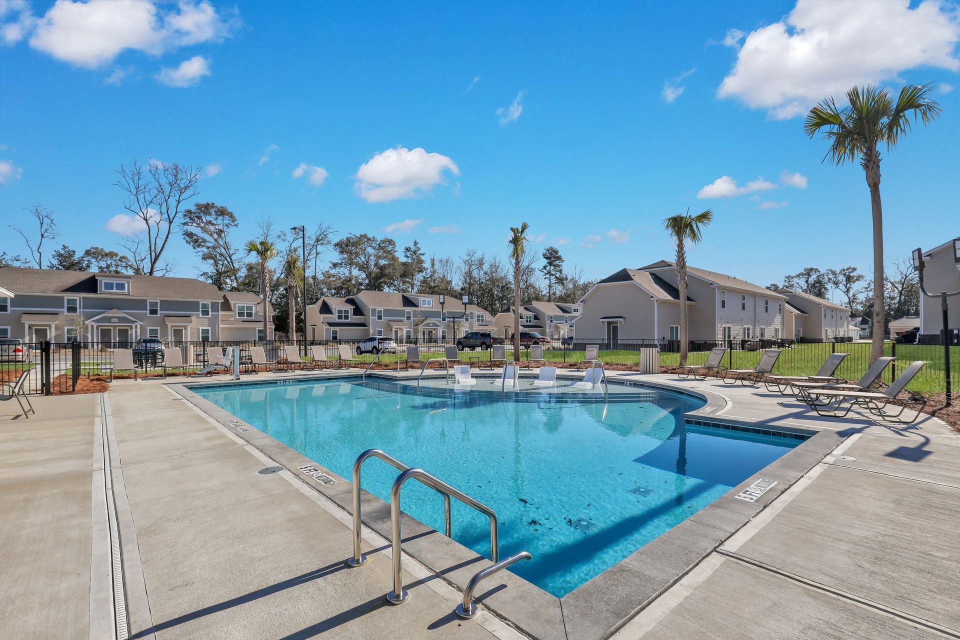 There is a large swimming pool in the middle of a residential area.