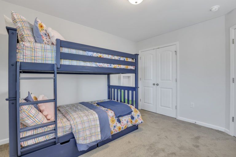 A bedroom with a bunk bed and a closet.
