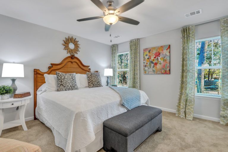 A bedroom with a large bed and a ceiling fan