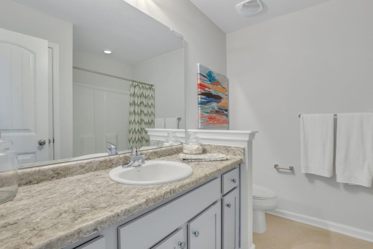 A bathroom with a sink , toilet , and mirror.