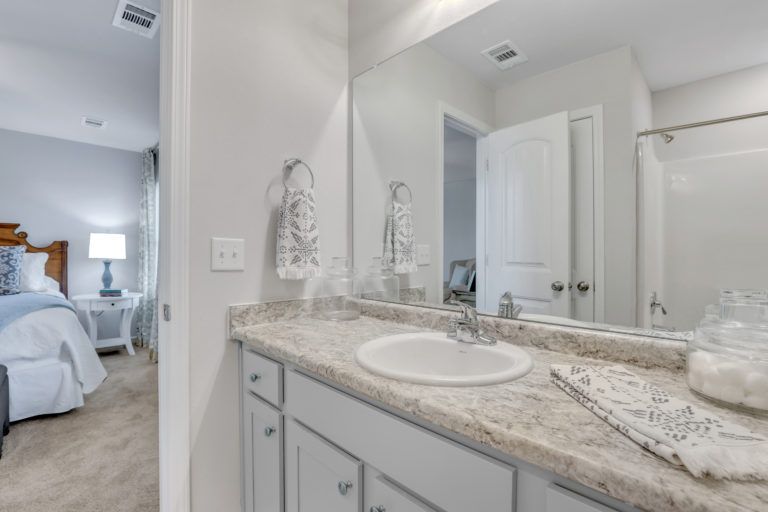 A bathroom with a sink and a large mirror.