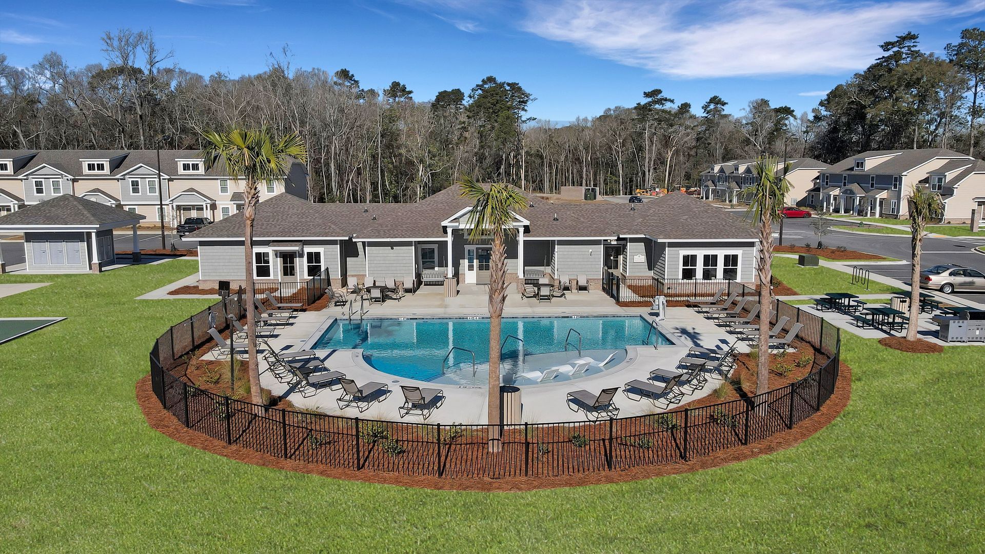 An aerial view of a swimming pool surrounded by chairs and a fence.