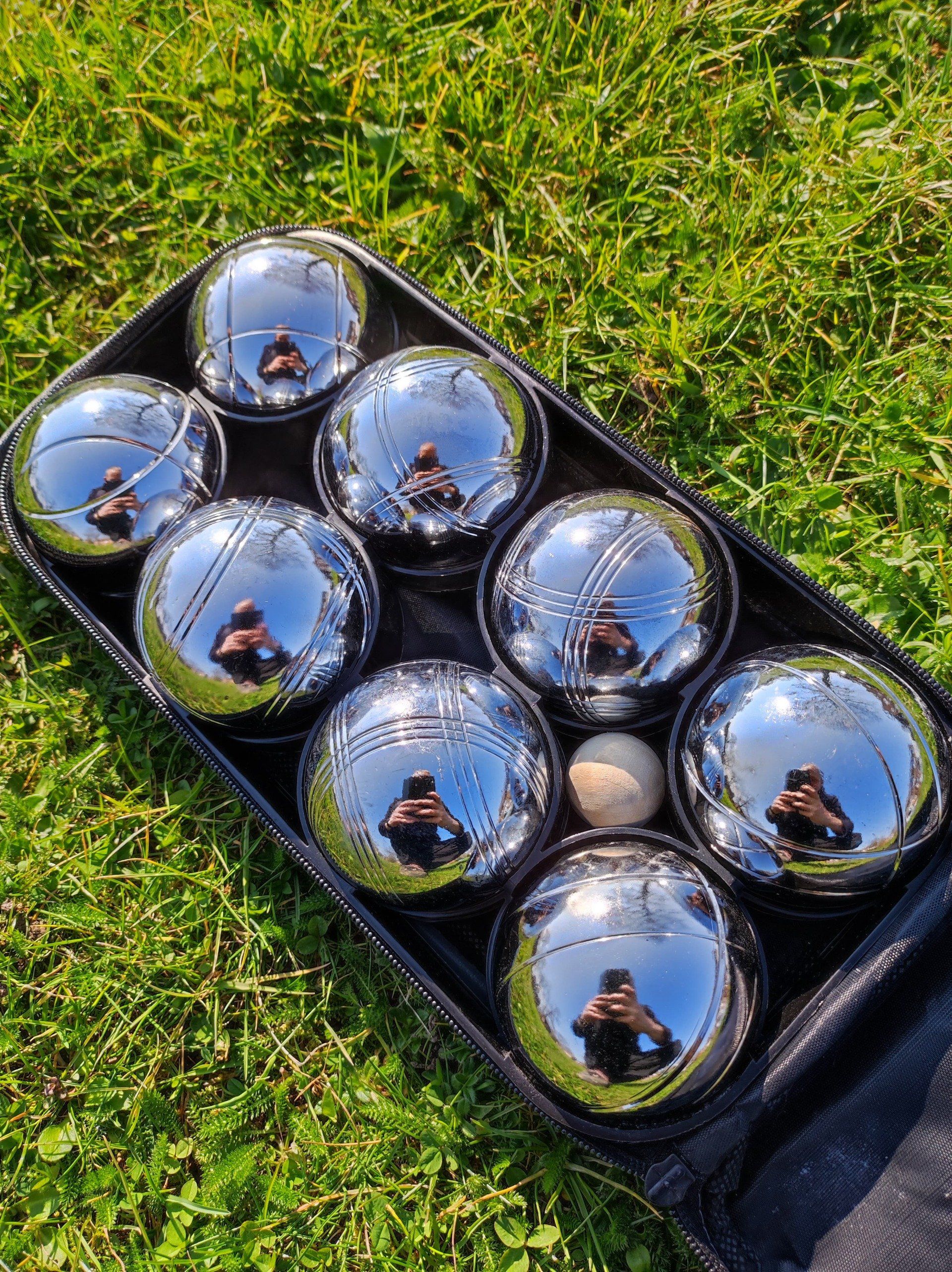8 French Boules balls in a carry case on green grass