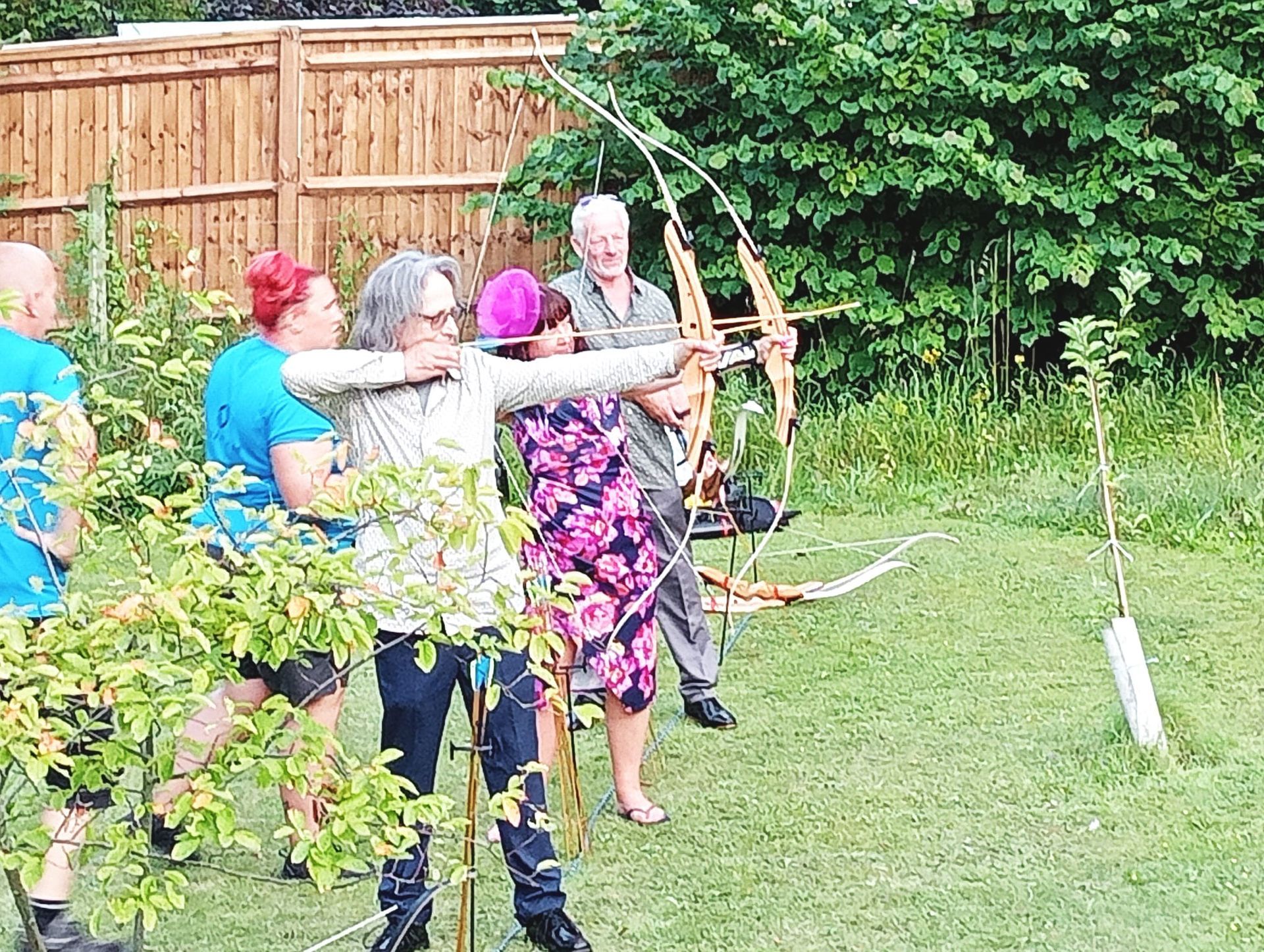 Archery hire in Hampshire, people holding bows and others watching