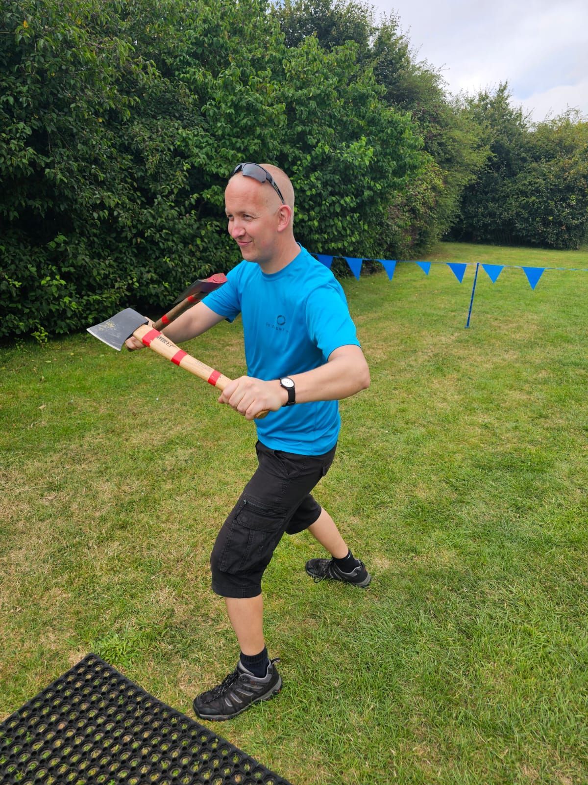 GO Event Hire owner holding 2 axes wearing a blue top