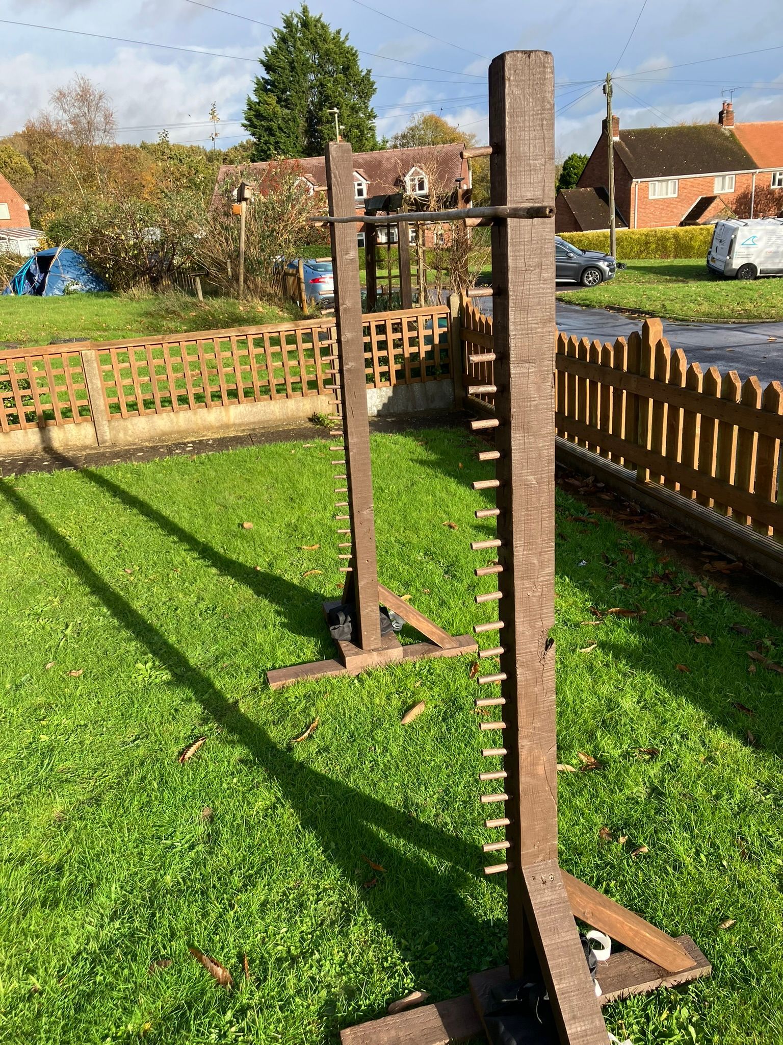 Wooden limbo lawn game in a garden.