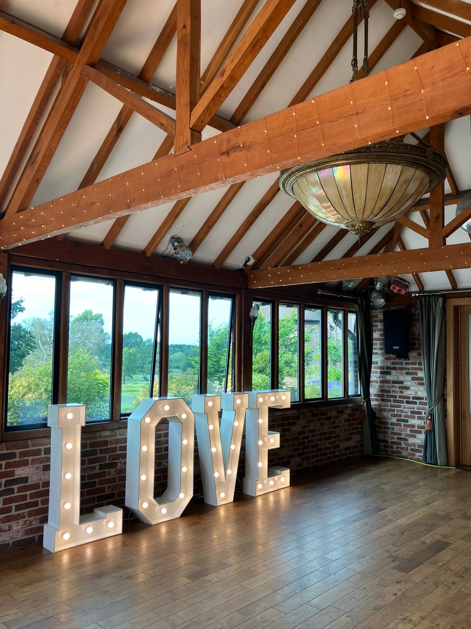 4 foot tall white light up love letters on a dance floor at a hotel for a wedding.