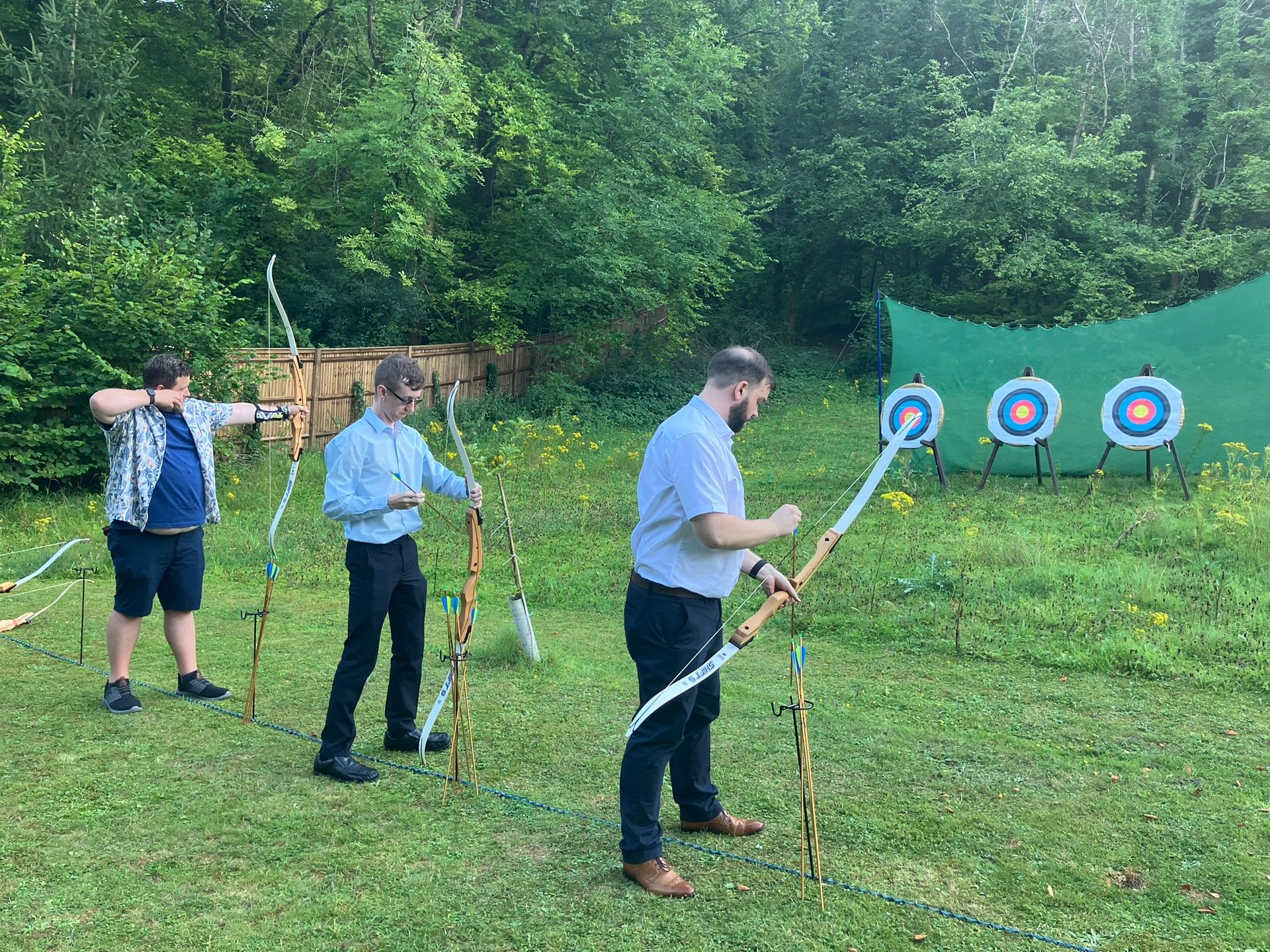 Archery hire in Hampshire, people holding bows and others watching