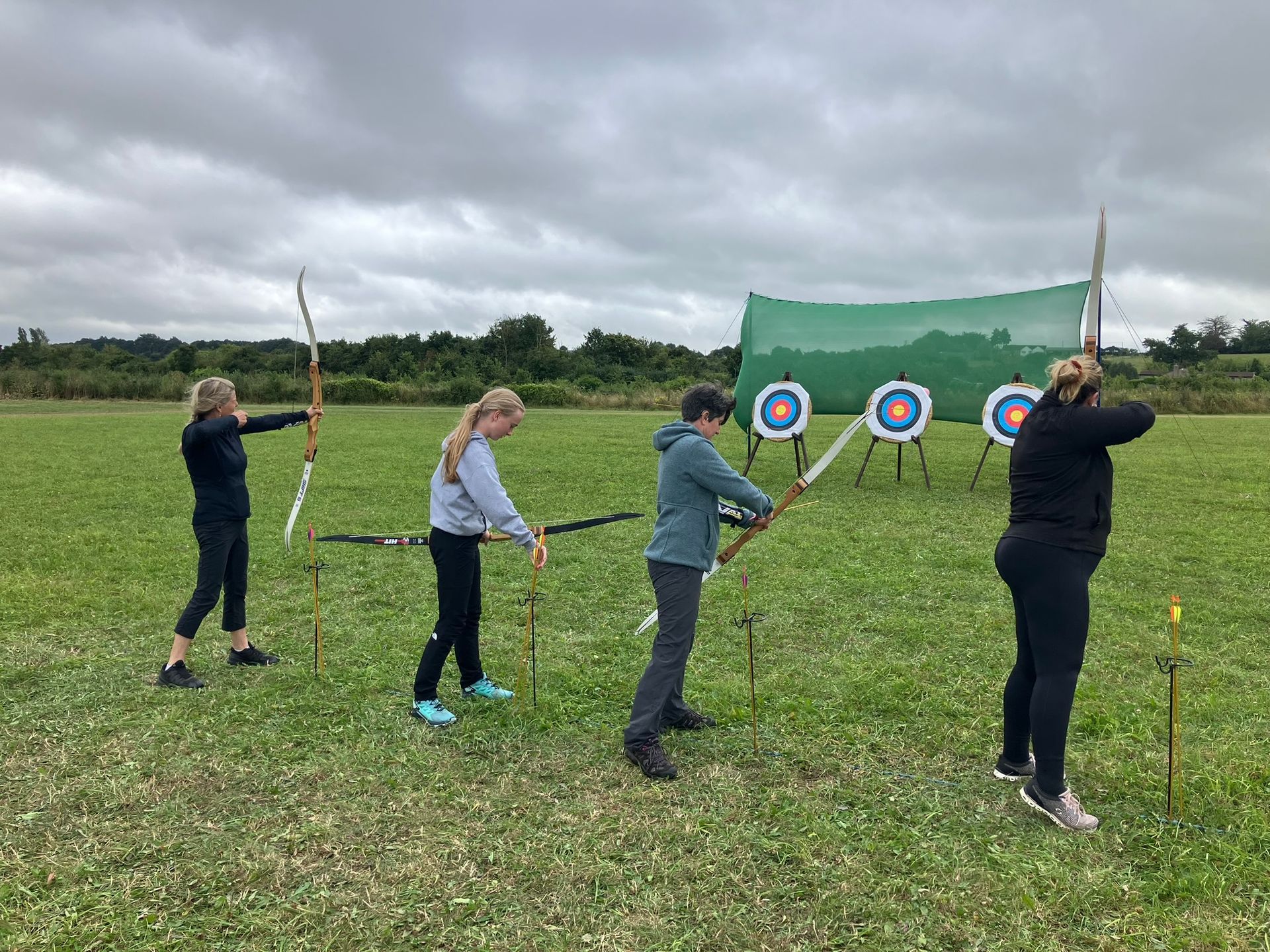 Archery hire in Hampshire, people holding bows and others watching