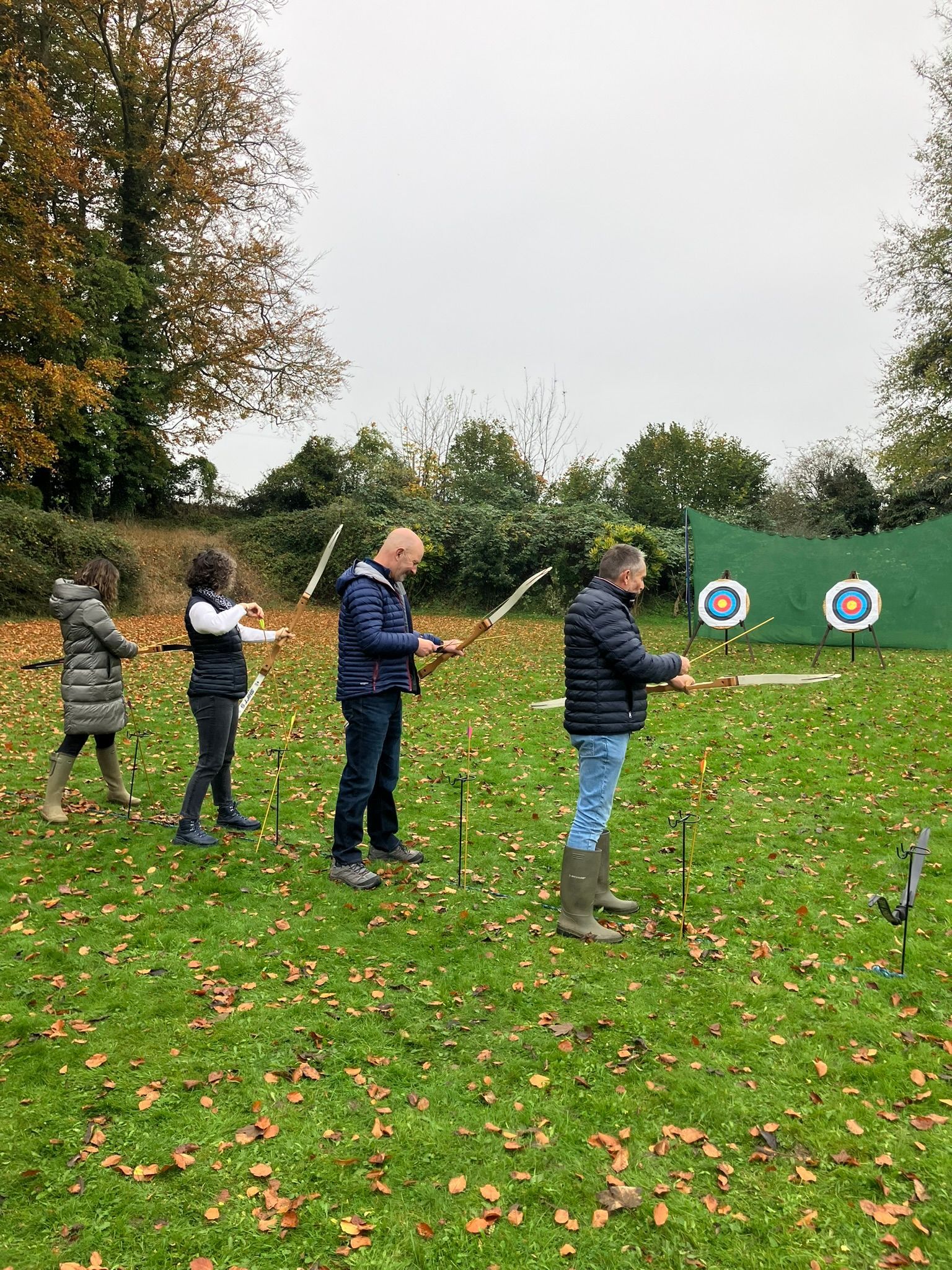 two archery targets set up in a field in Hampshire with 4 people aiming