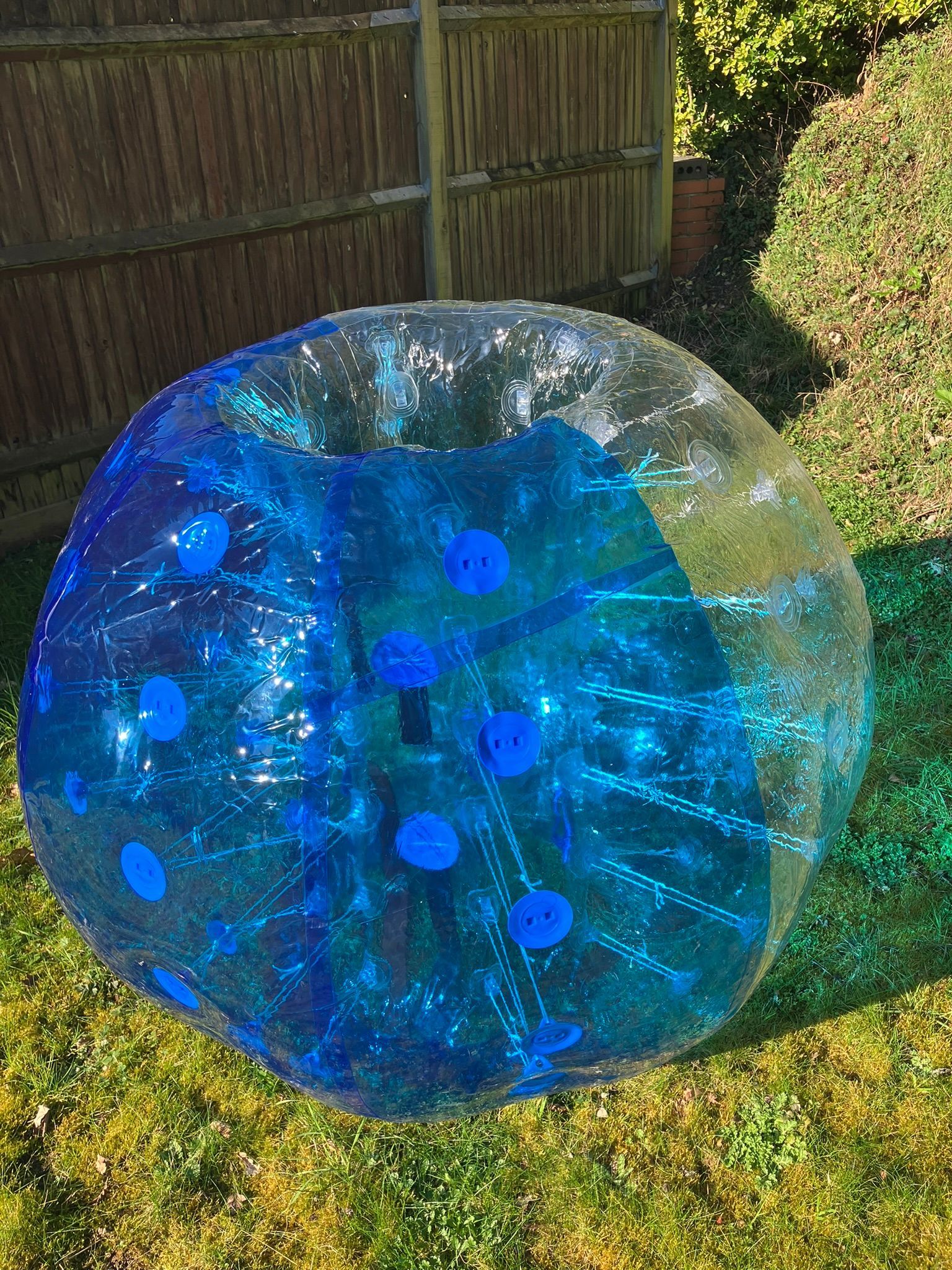 A giant blue blow up bubble football on grass.