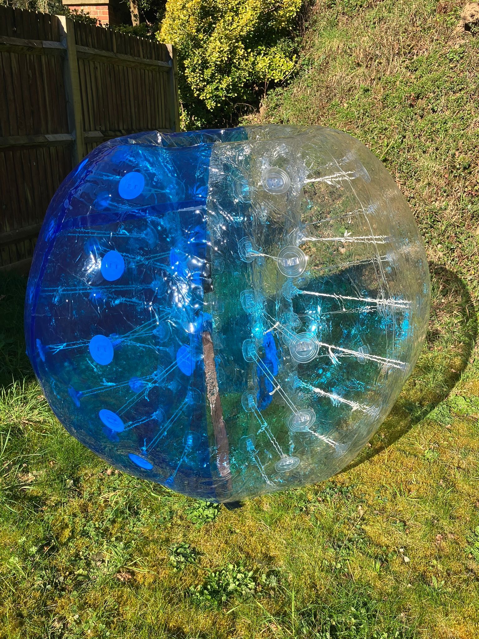 A giant blue blow up bubble football on grass.