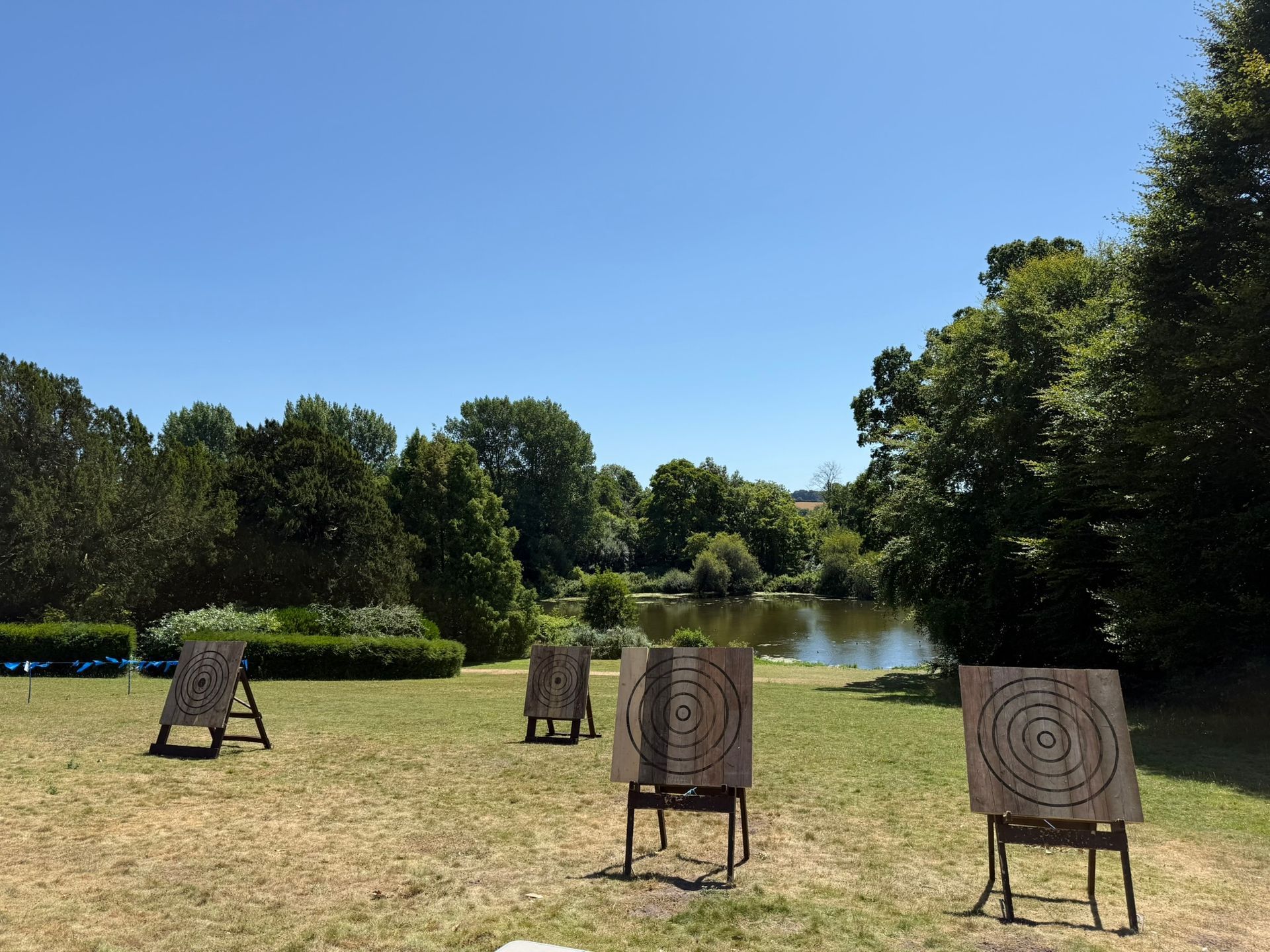 Corporate axe throwing hire in Hampshire. 4 targets set up on grass at a hotel.