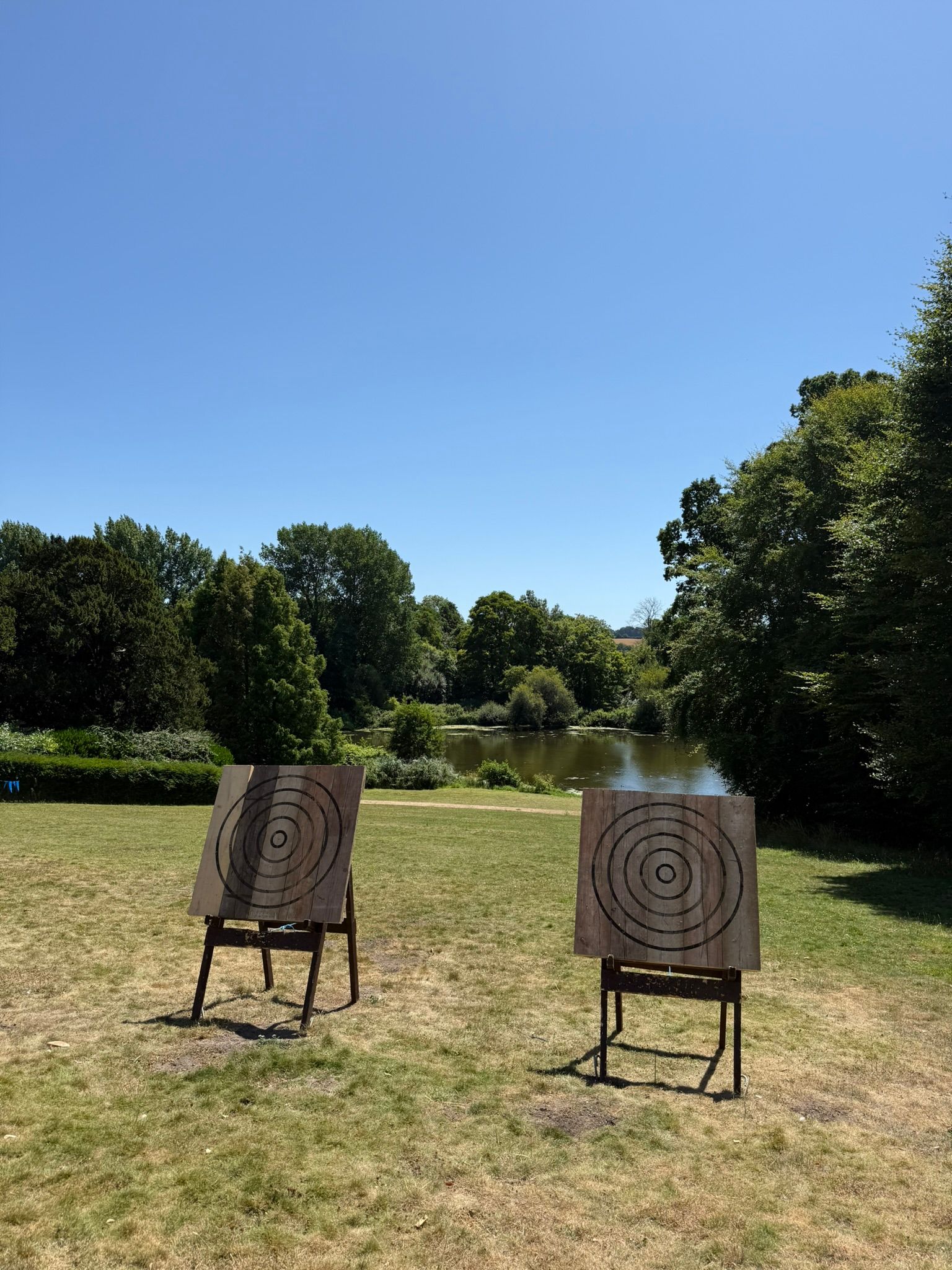 Corporate axe throwing hire in Hampshire. 4 targets set up on grass at a hotel.