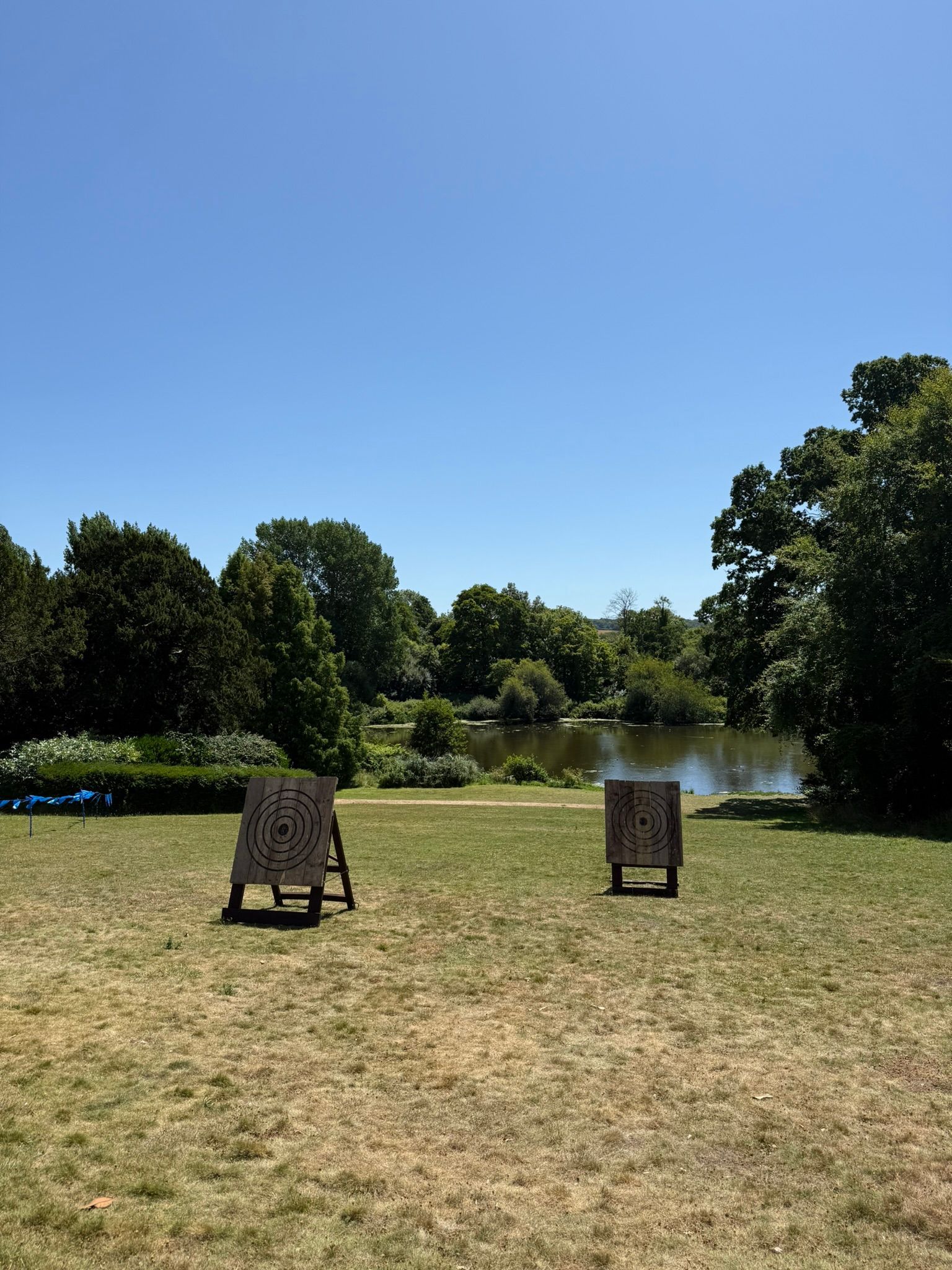 Corporate axe throwing hire in Hampshire. 4 targets set up on grass at a hotel.