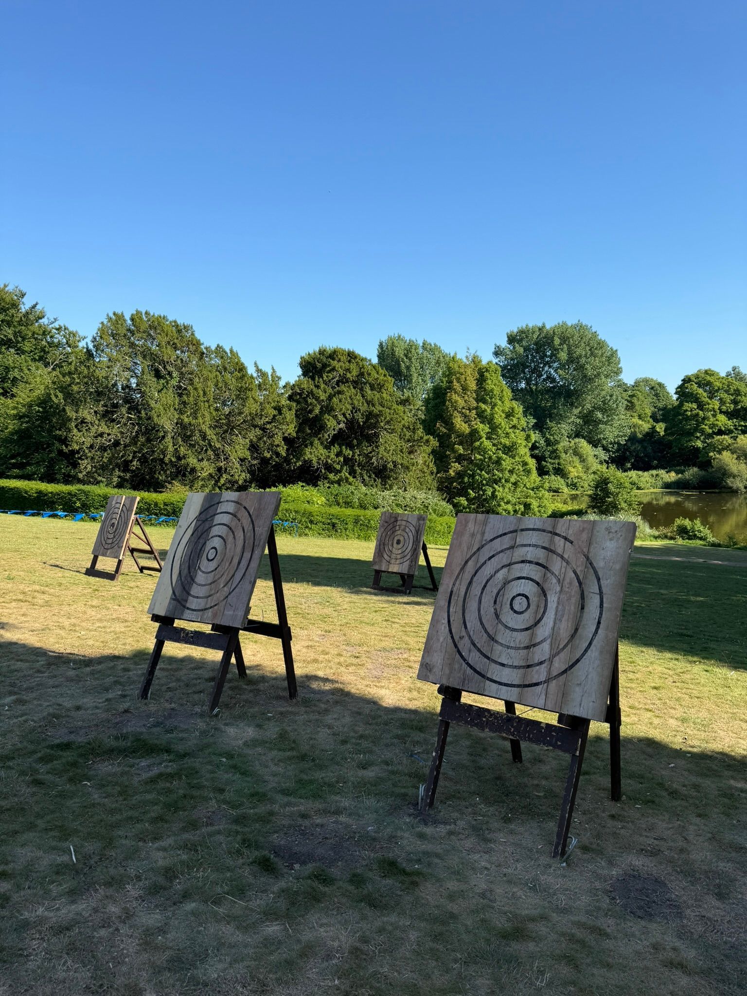Corporate axe throwing hire in Hampshire. 4 targets set up on grass at a hotel.