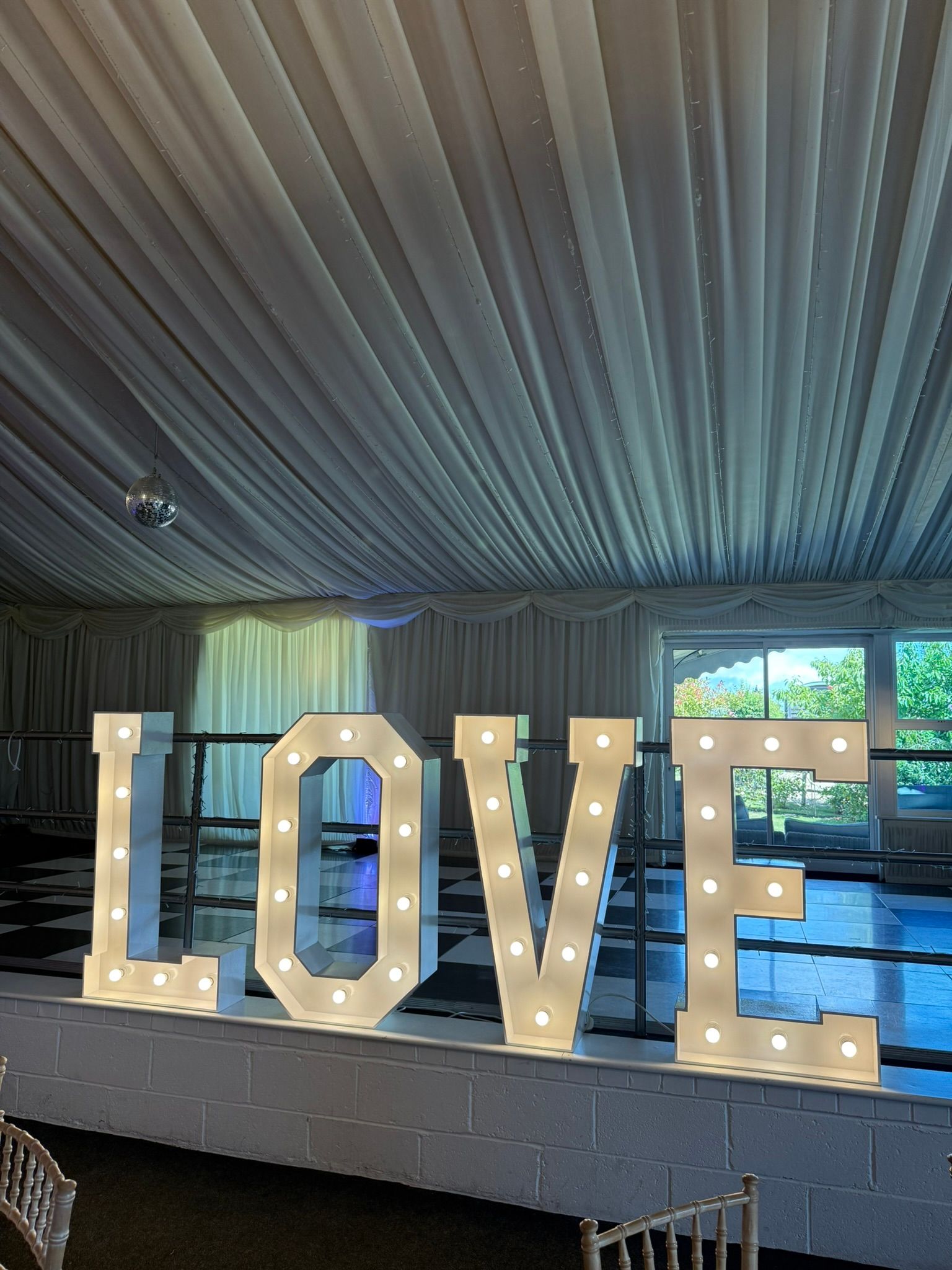 A 10 foot wide and 8 foot tall curved backdrop with sparkly gold design.