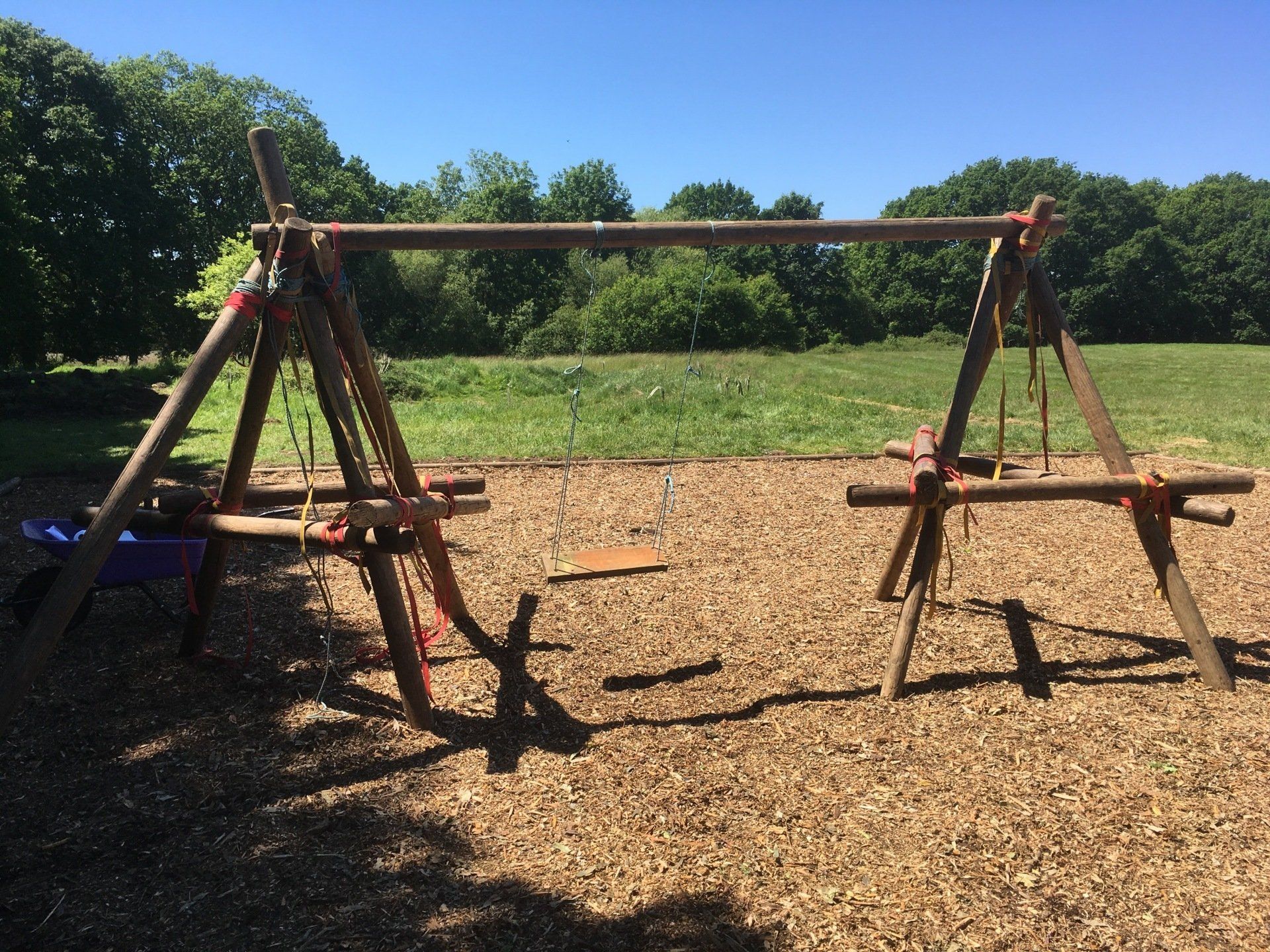 Wooden pioneering poles joined to create a swing.