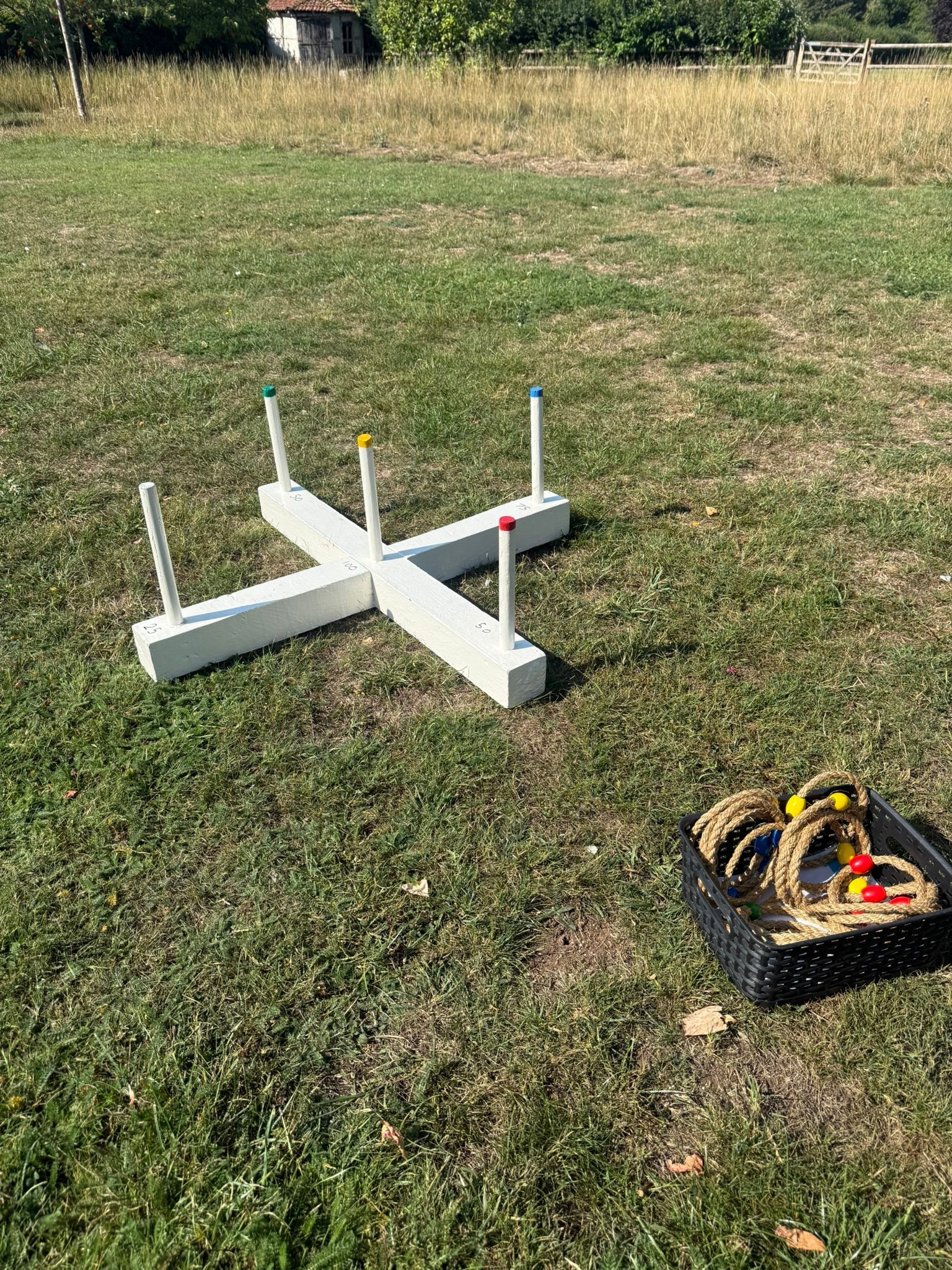 Wooden white lawn game ring toss on grass.