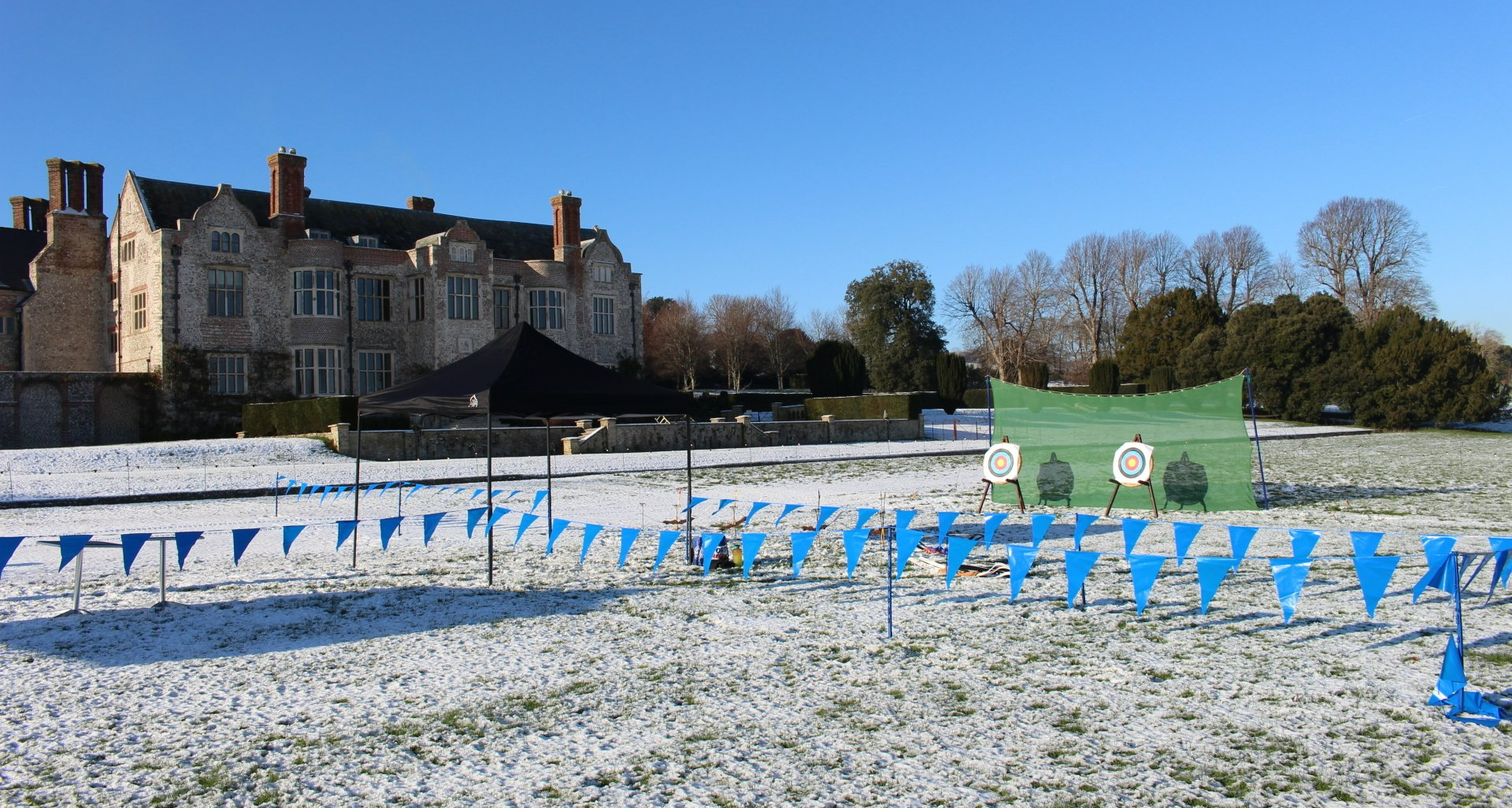 Corporate outdoor event at Glynde Place.  snow on the ground, archery and axe throwing set up