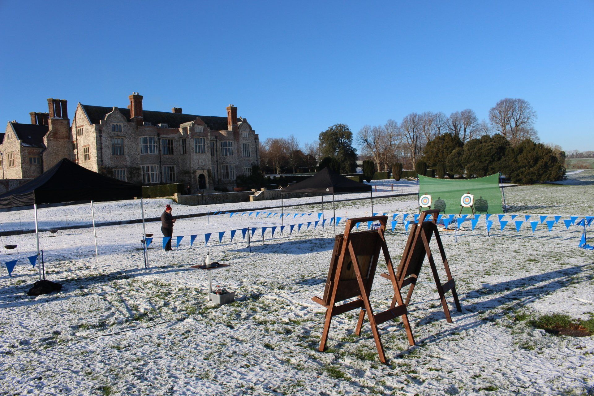 Snow covered ground at a hotel with axe throwing targets set up.