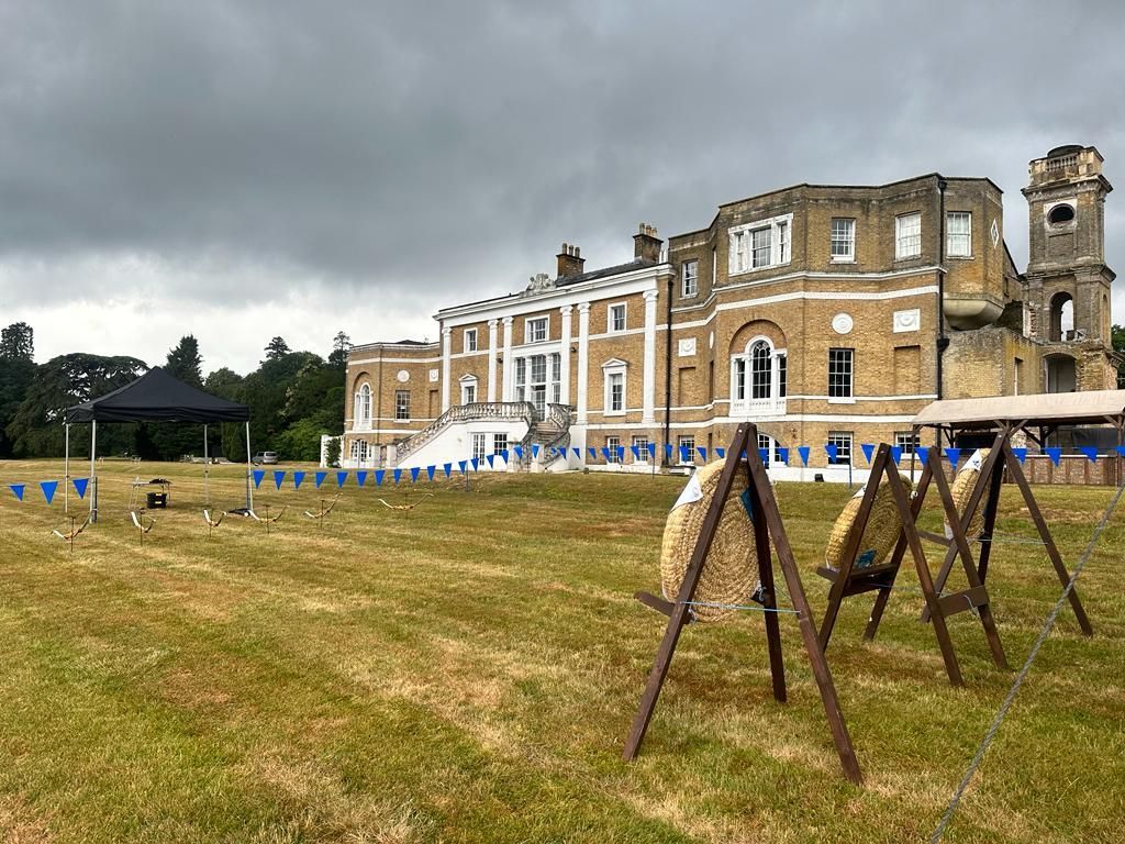 3 archery targets set up for a corporate archery event on a field at a hotel.